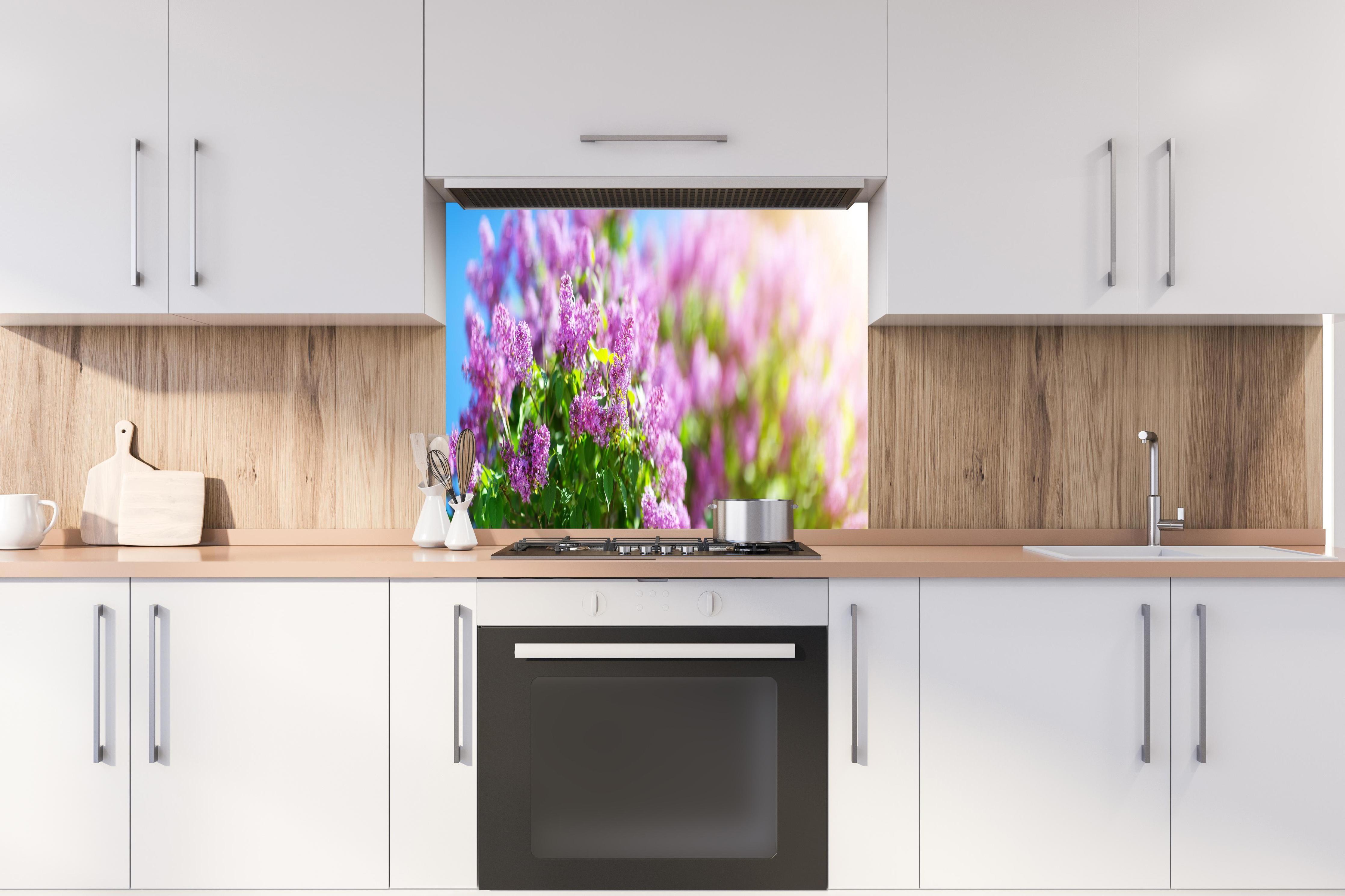 Spritzschutz - Blumen blühen auf im Frühling hinter einem Cerankochfeld zwischen Holz-Kochutensilien