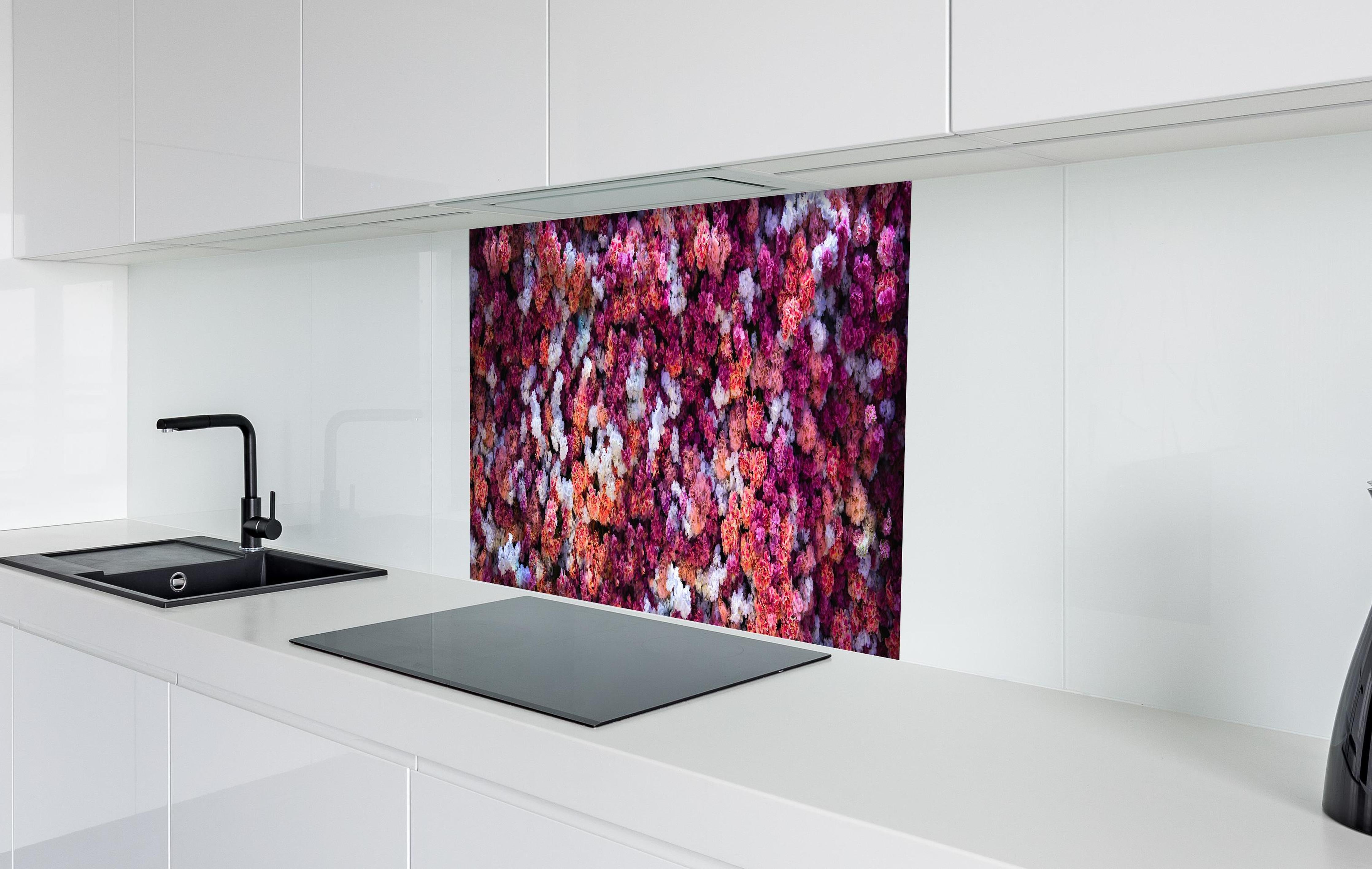 Spritzschutz - Blumenwand in Rot und Weiß Naturhintergrund hinter einem Cerankochfeld zwischen Holz-Kochutensilien