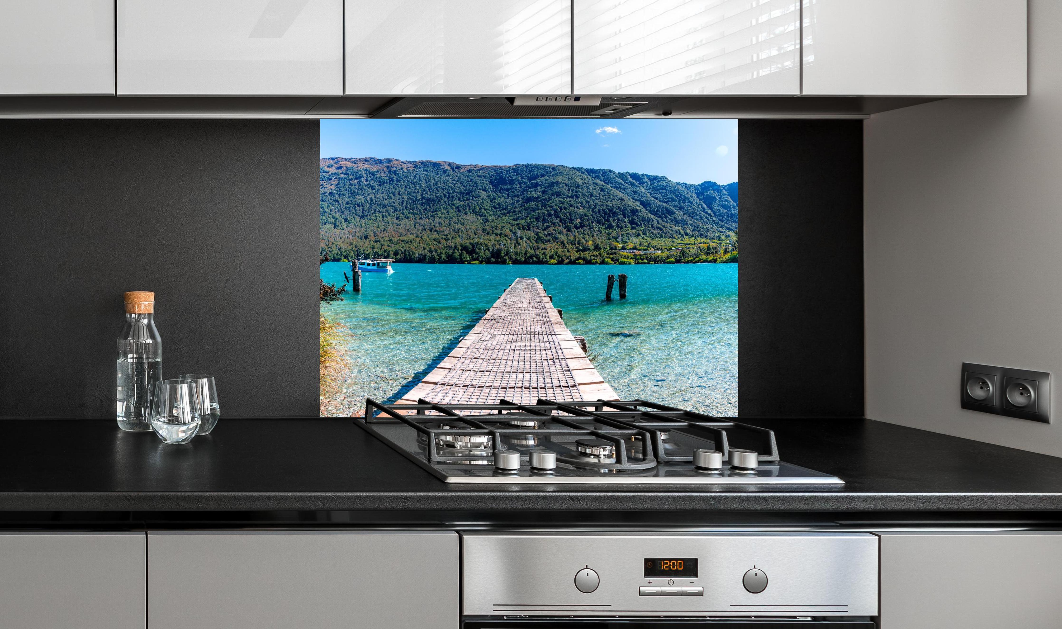 Spritzschutz - Bob's Cove Bucht in Neuseeland hinter einem Cerankochfeld zwischen Holz-Kochutensilien