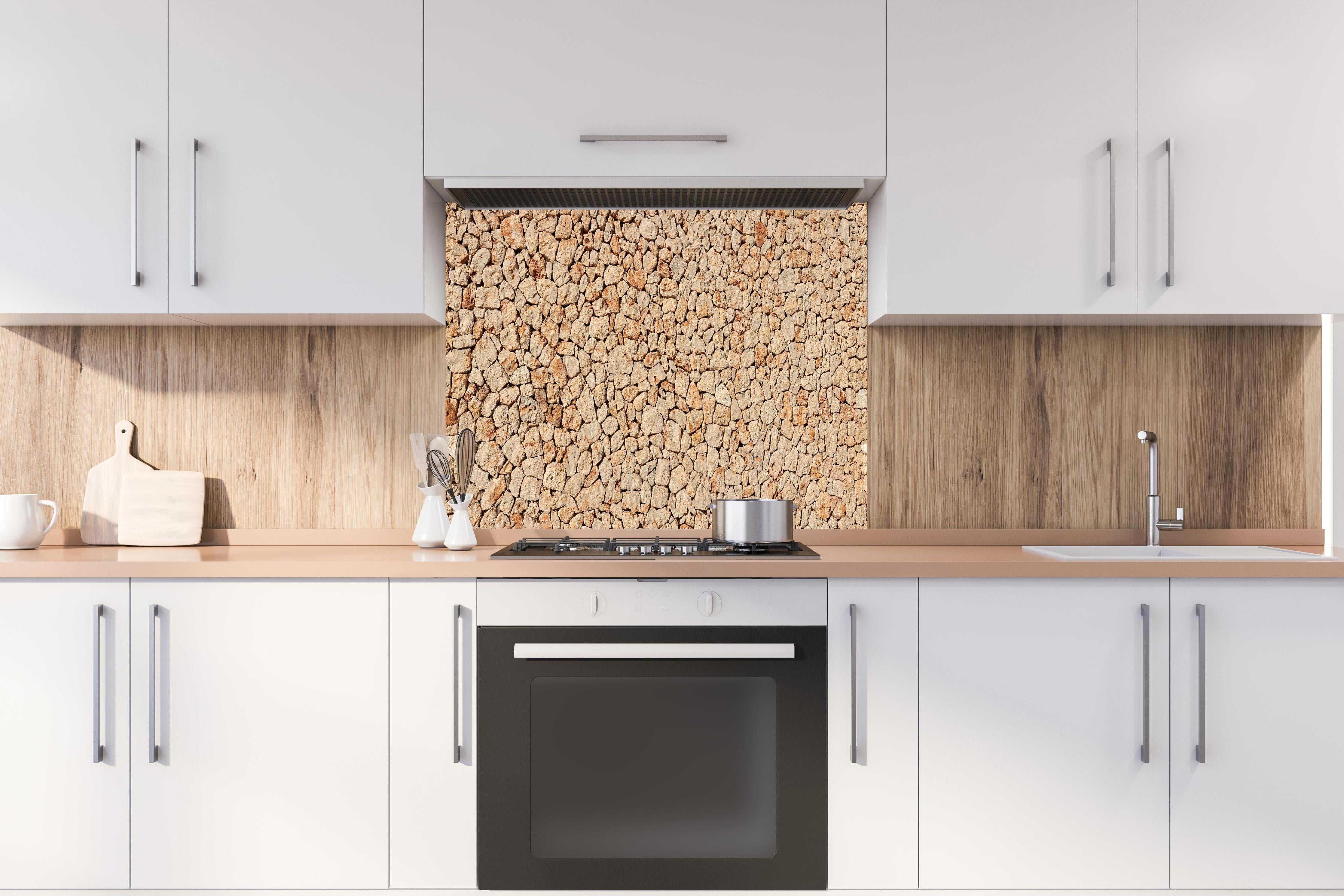 Spritzschutz - Bräunliche Panorama-Textur Steinmauer hinter einem Cerankochfeld zwischen Holz-Kochutensilien