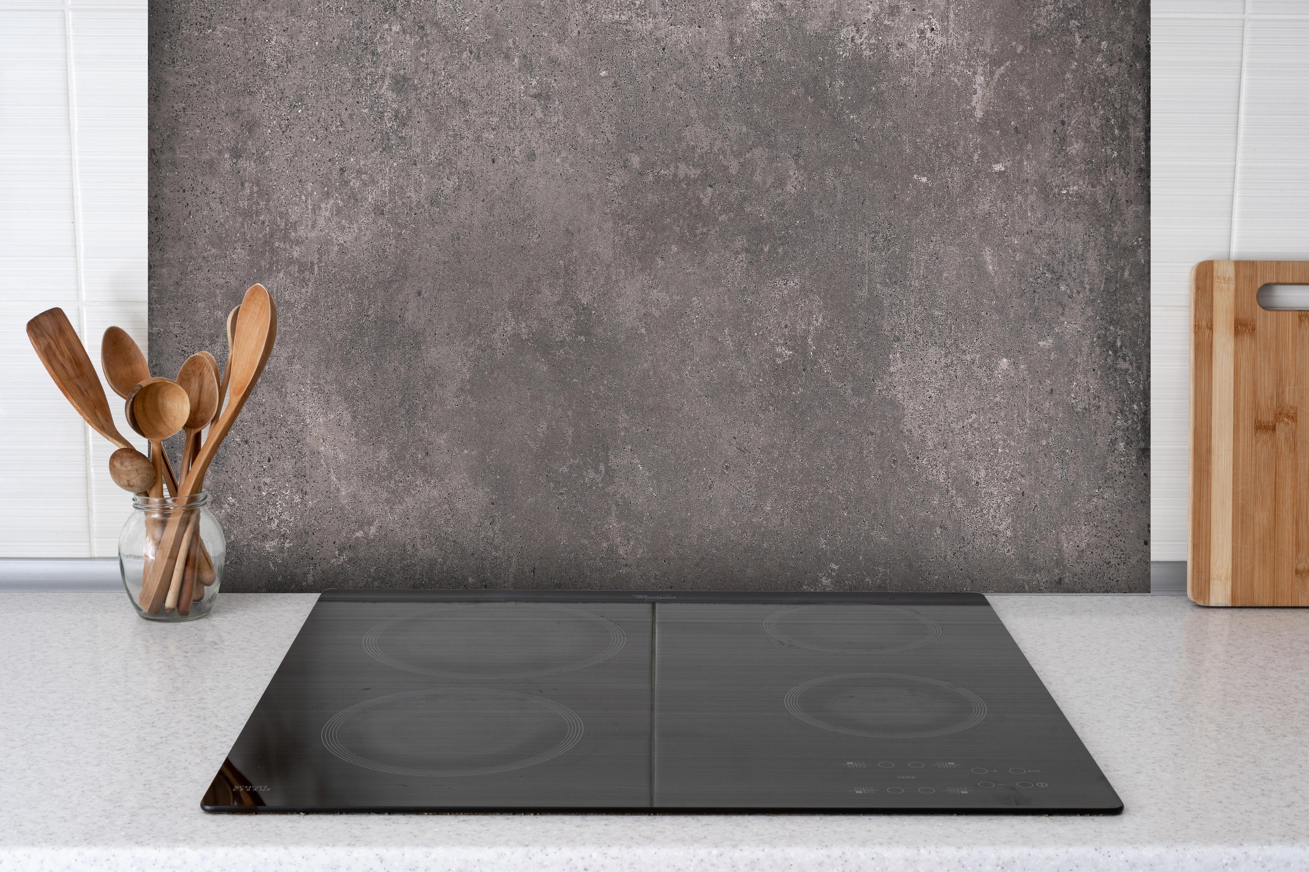 Spritzschutz - Bräunliche luxuriöse Marmortextur hinter einem Cerankochfeld zwischen Holz-Kochutensilien