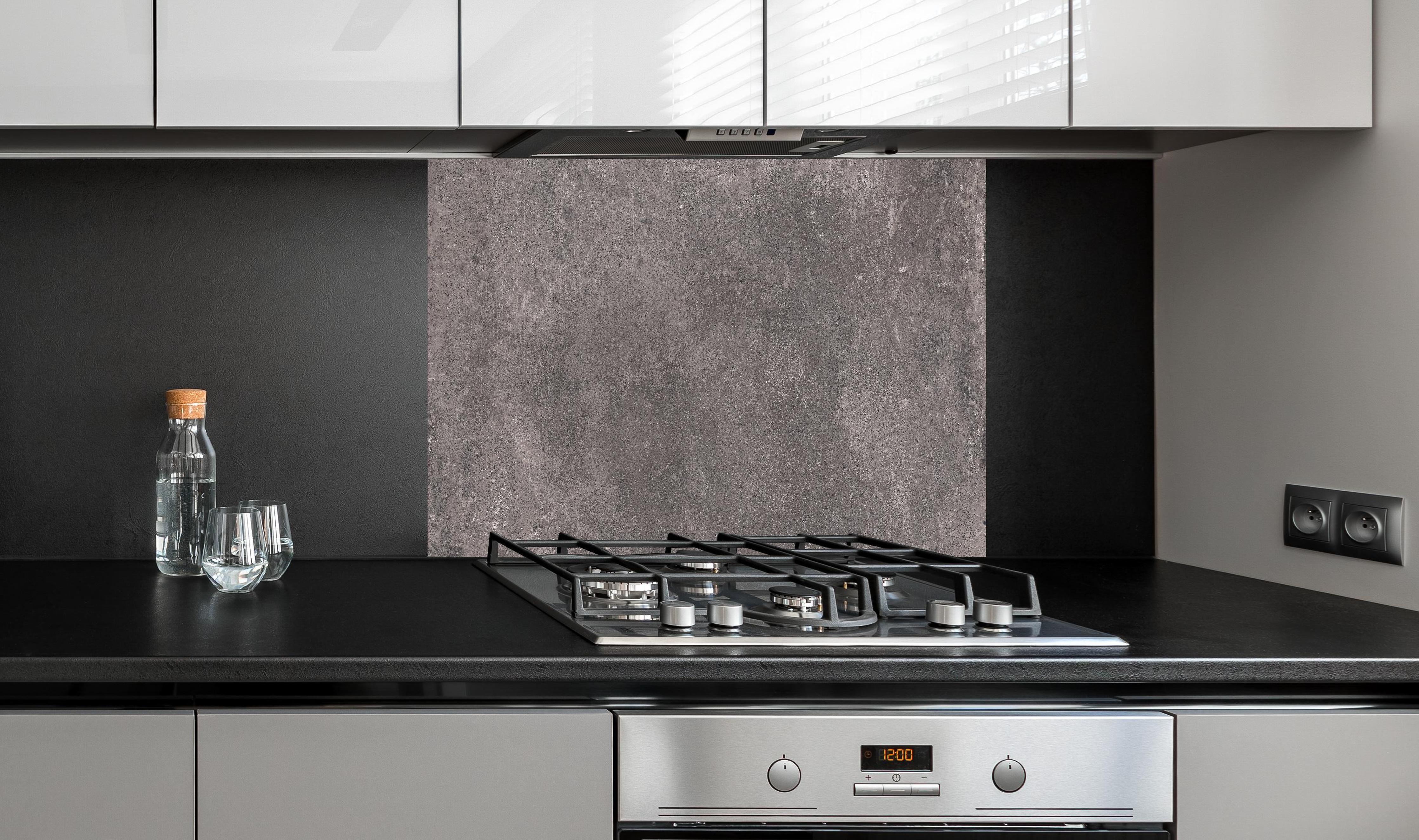 Spritzschutz - Bräunliche luxuriöse Marmortextur hinter einem Cerankochfeld zwischen Holz-Kochutensilien