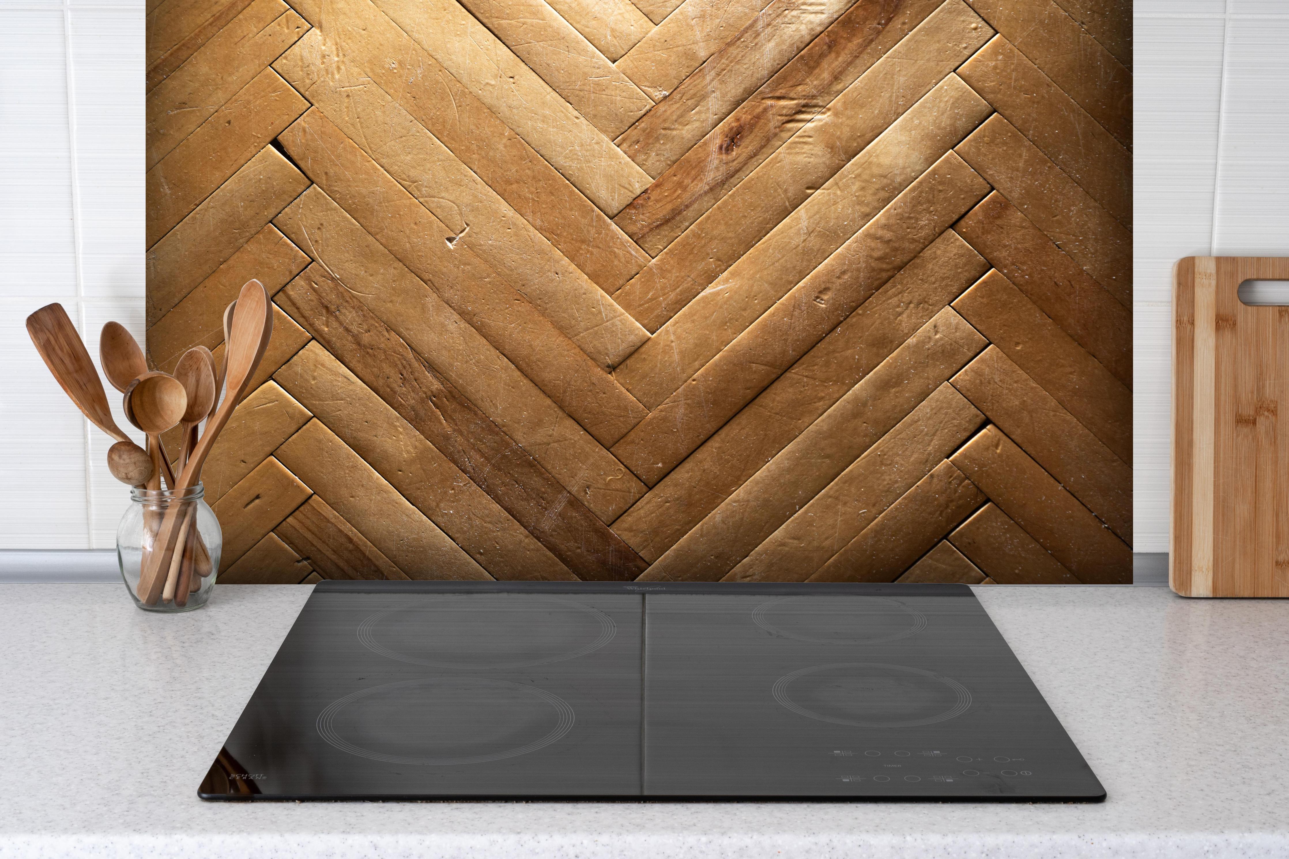 Spritzschutz - Bräunliches Holzbrett Muster hinter einem Cerankochfeld zwischen Holz-Kochutensilien