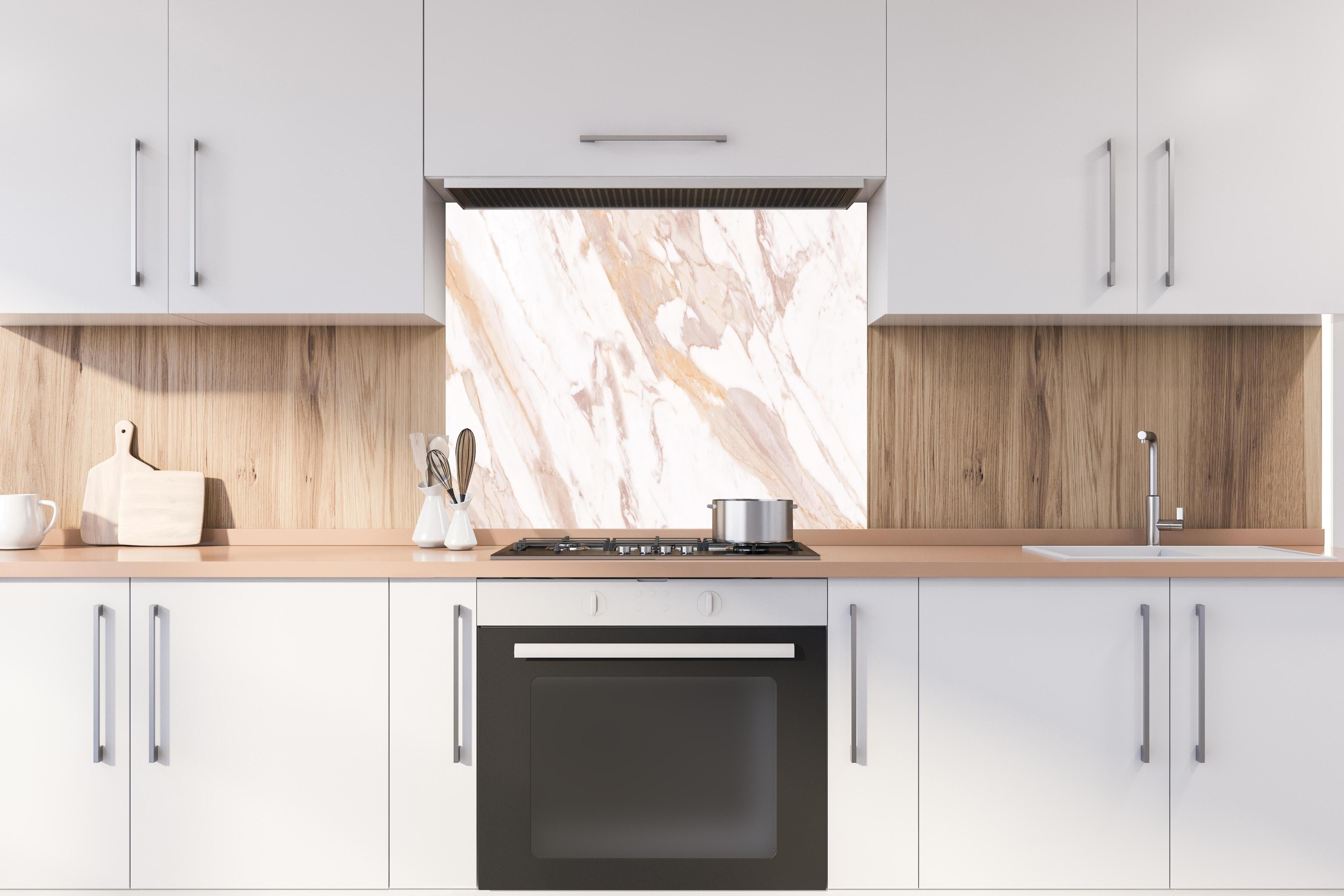 Spritzschutz - Braun-beiger Marmor hinter einem Cerankochfeld zwischen Holz-Kochutensilien
