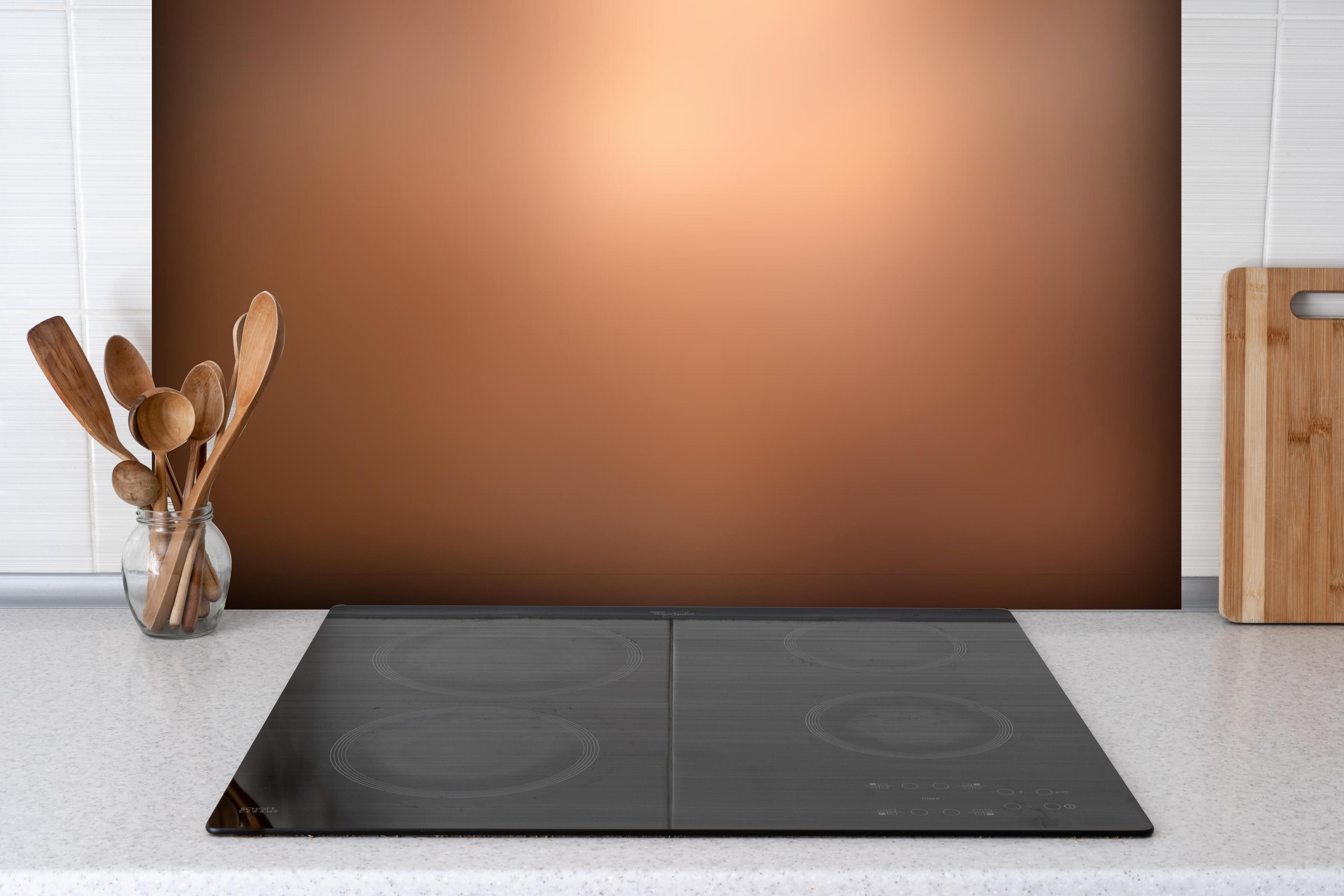 Spritzschutz - Braun, beiges Muster hinter einem Cerankochfeld zwischen Holz-Kochutensilien