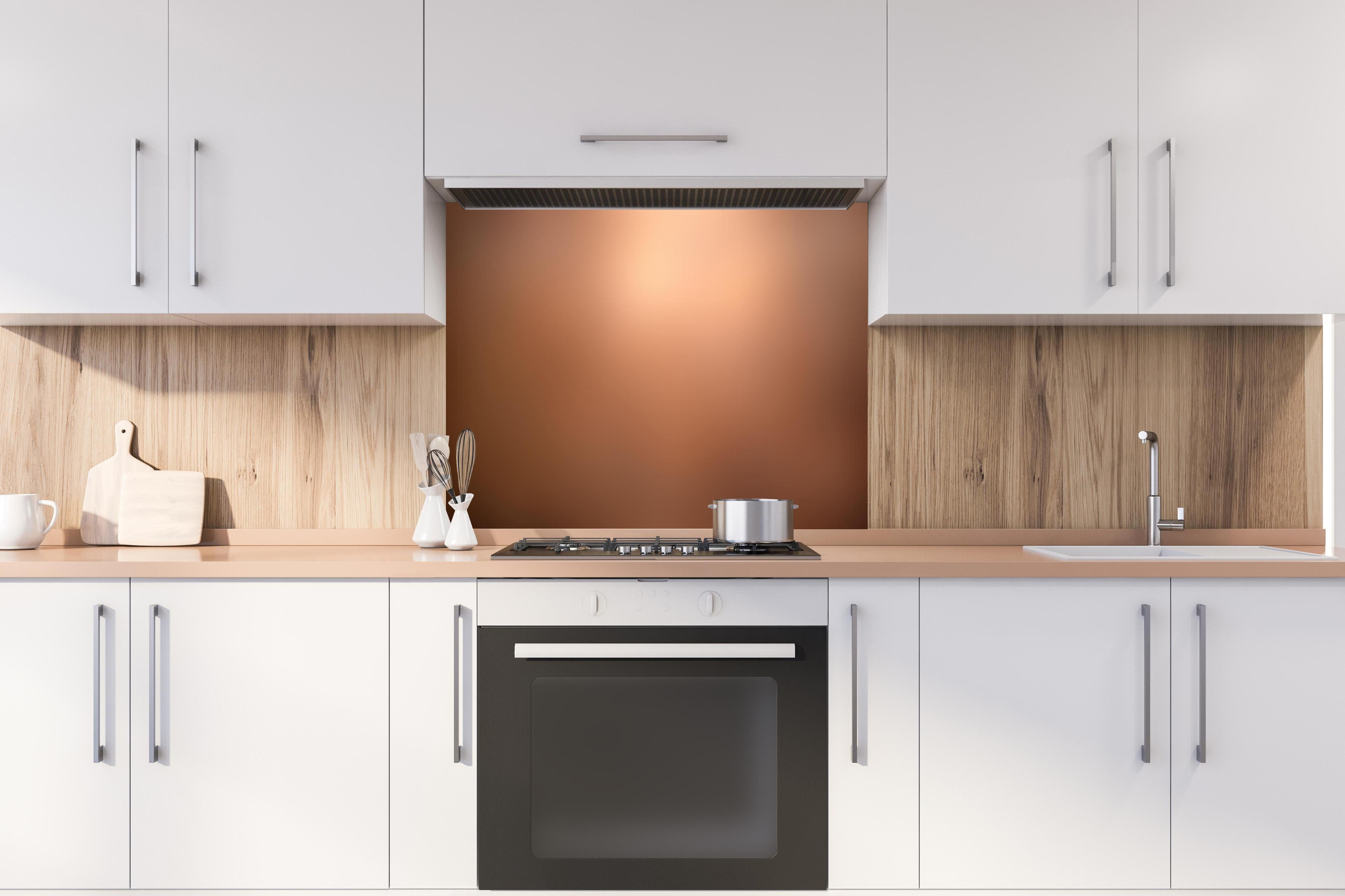 Spritzschutz - Braun, beiges Muster hinter einem Cerankochfeld zwischen Holz-Kochutensilien