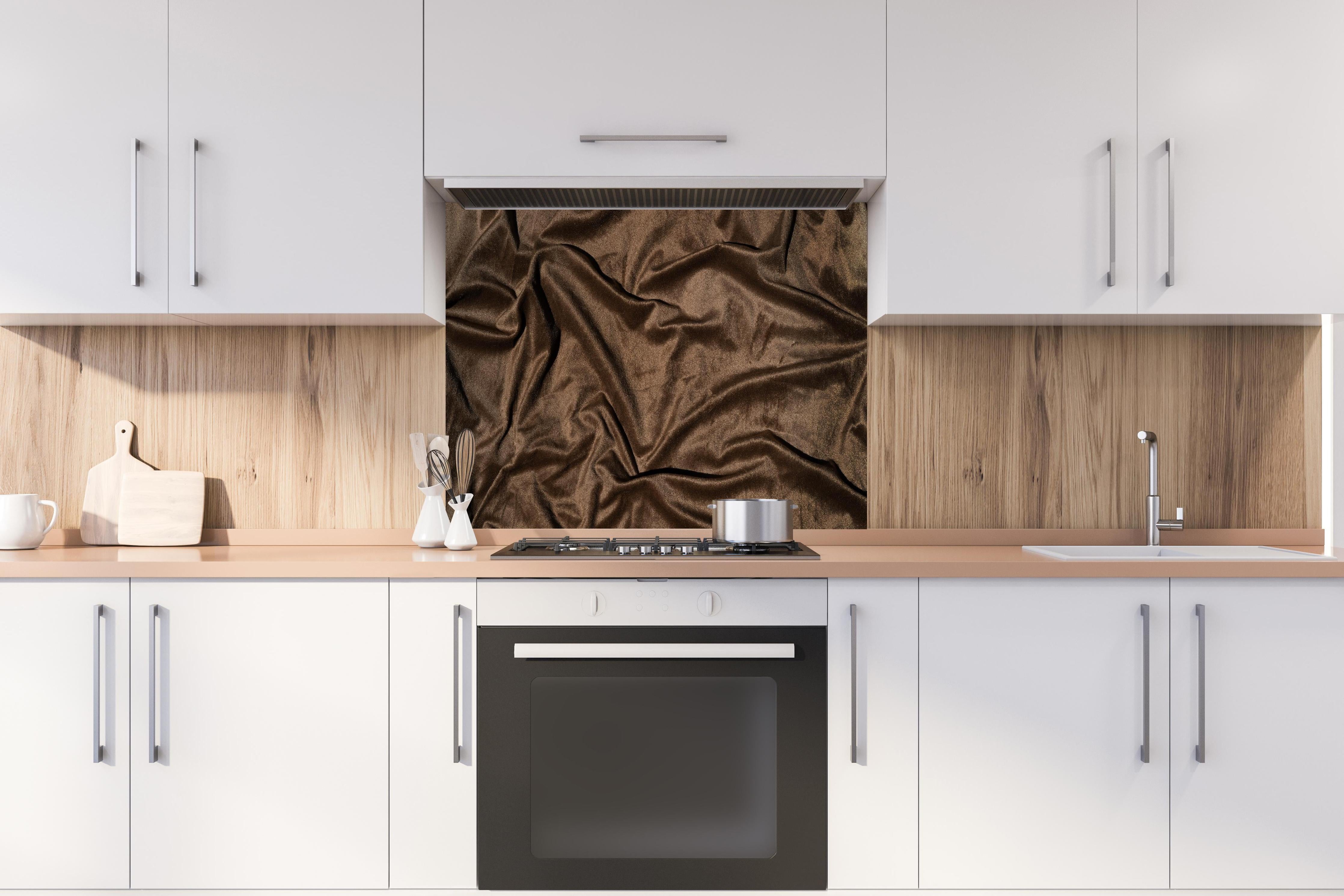 Spritzschutz - Braune Satin Seide hinter einem Cerankochfeld zwischen Holz-Kochutensilien