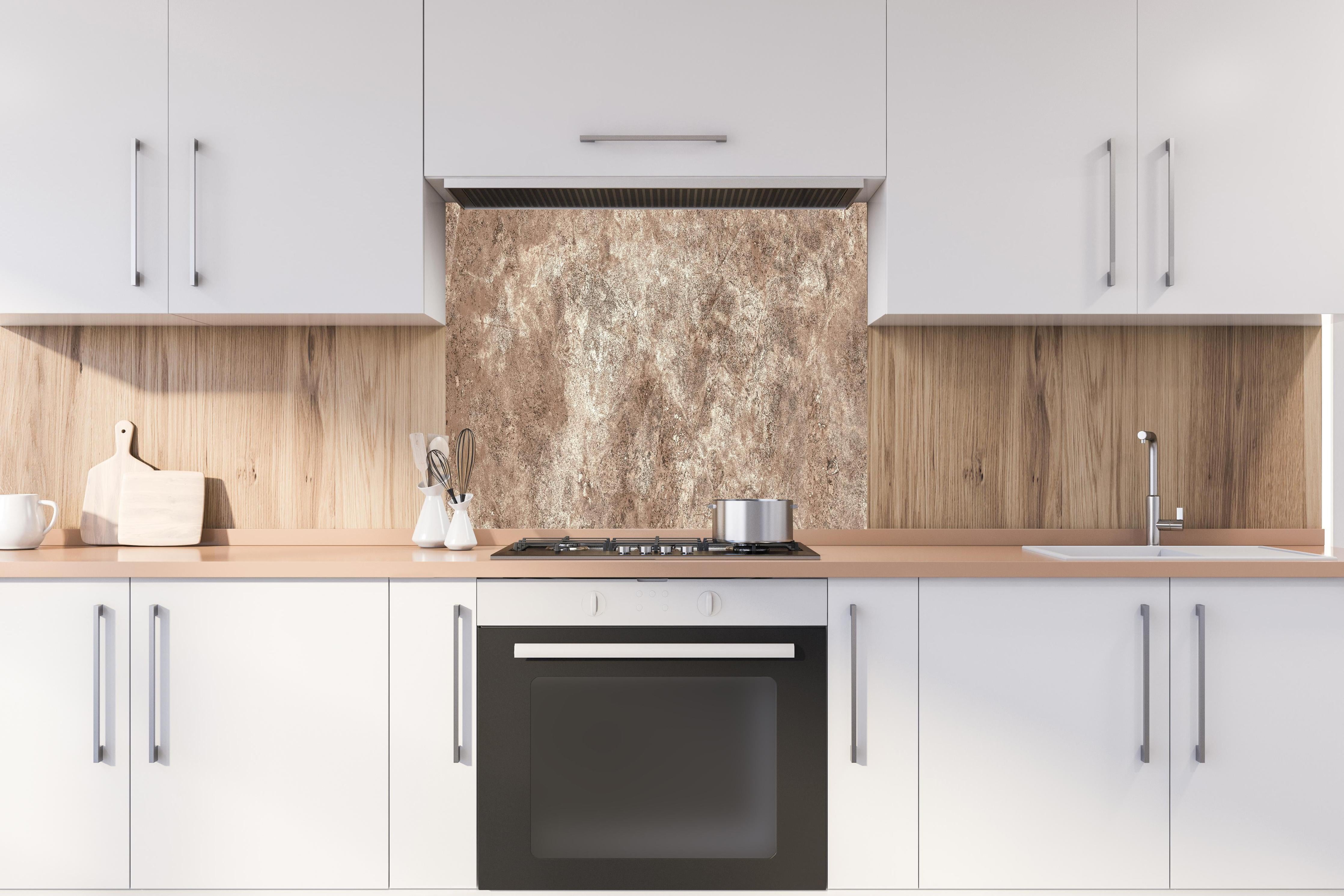 Spritzschutz - Brauner alter Sandstein 2 hinter einem Cerankochfeld zwischen Holz-Kochutensilien