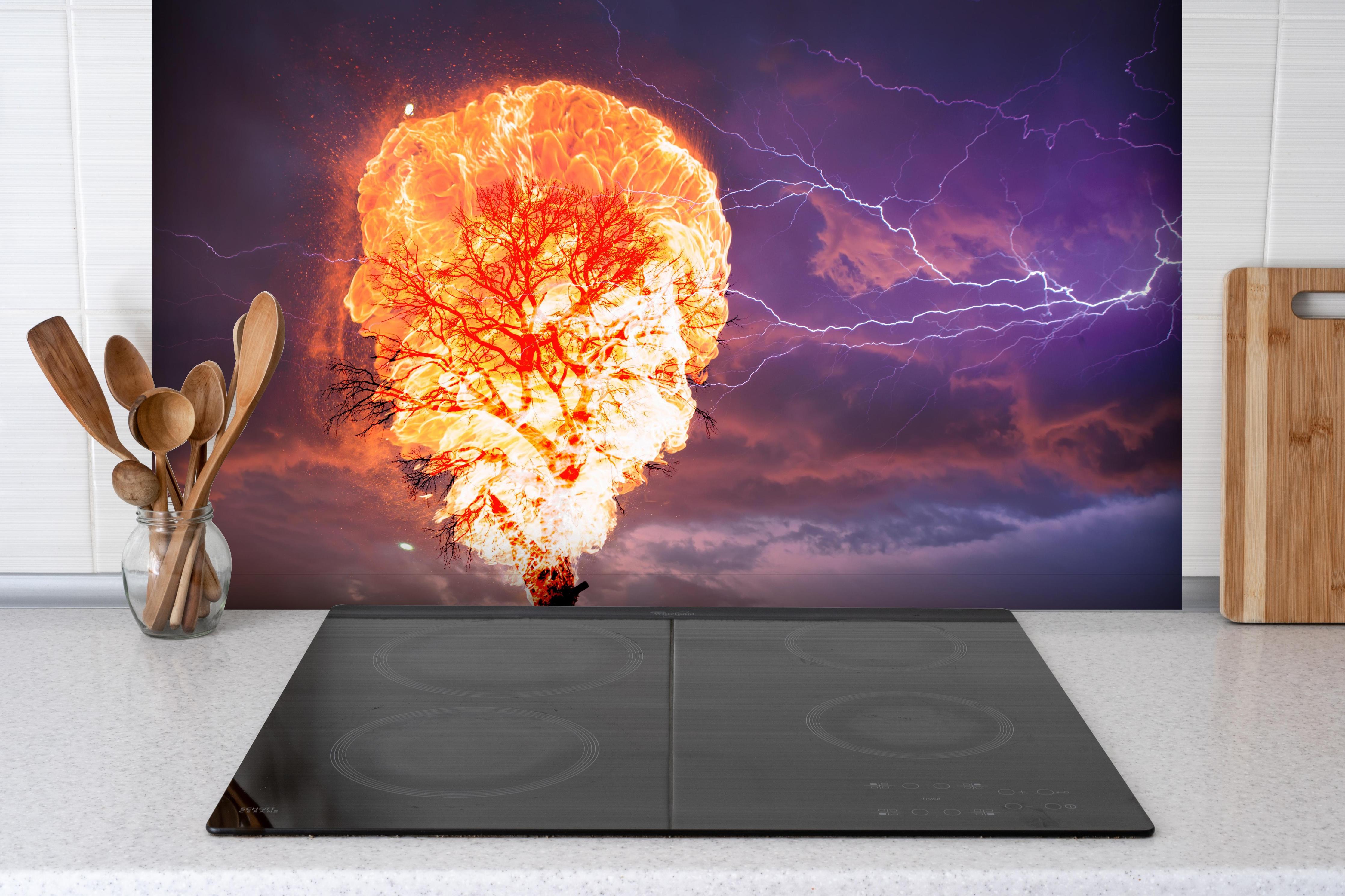 Spritzschutz - Brennender Baum bei Gewittersturm hinter einem Cerankochfeld zwischen Holz-Kochutensilien
