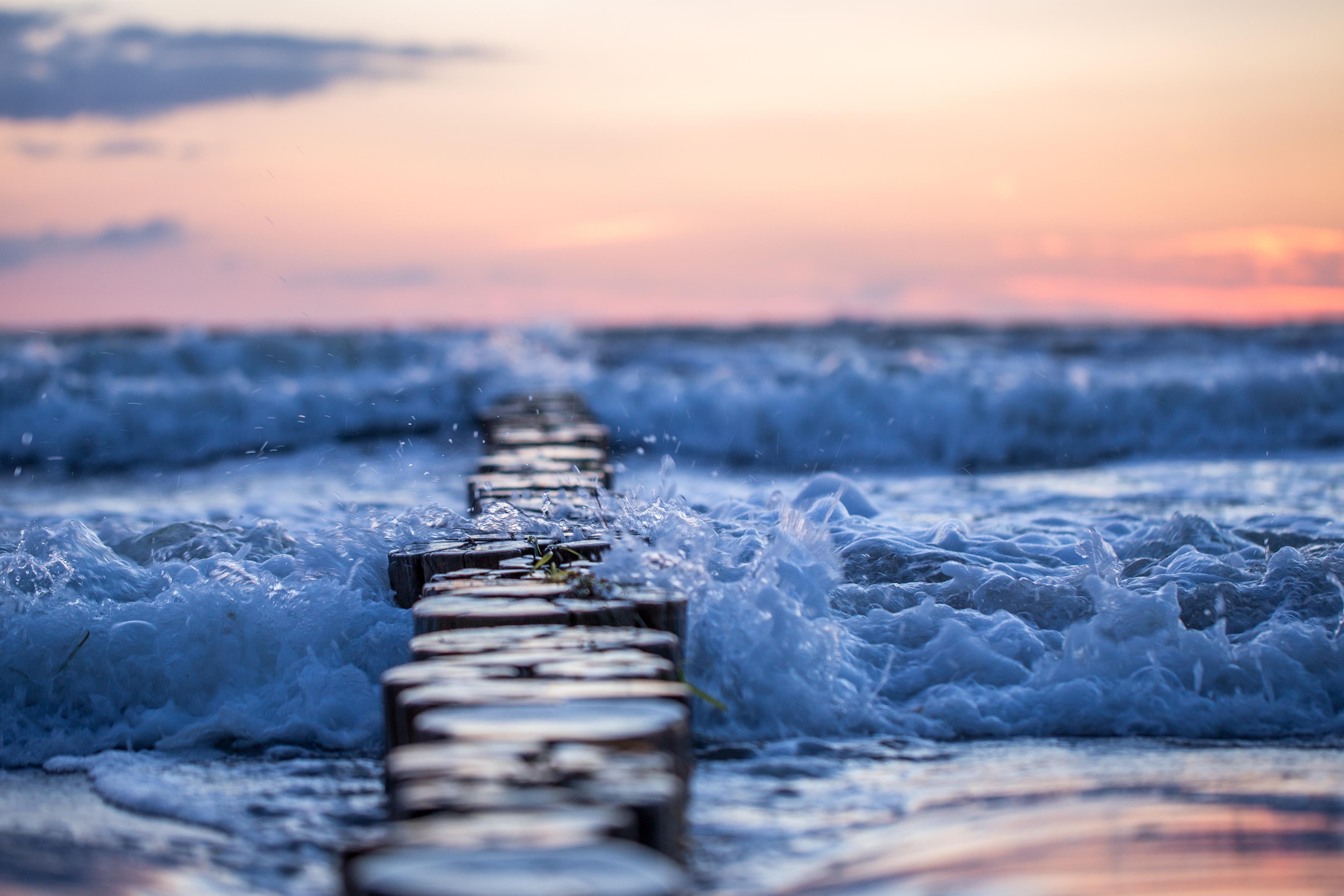 Spritzschutz-Buhnen im Meer bei Sonnenaufgang