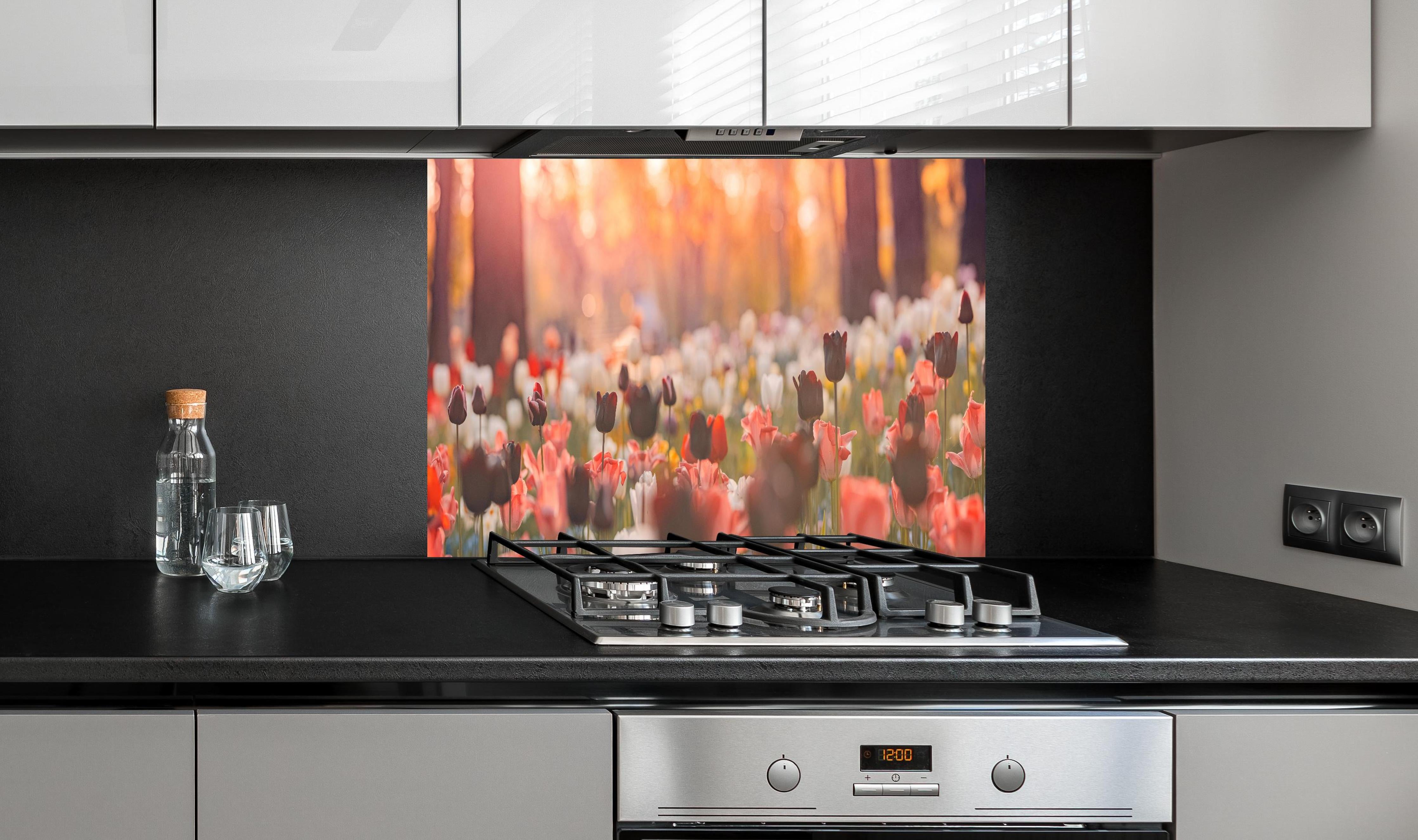 Spritzschutz - Bunte Blumenwiese mit Tulpen hinter einem Cerankochfeld zwischen Holz-Kochutensilien