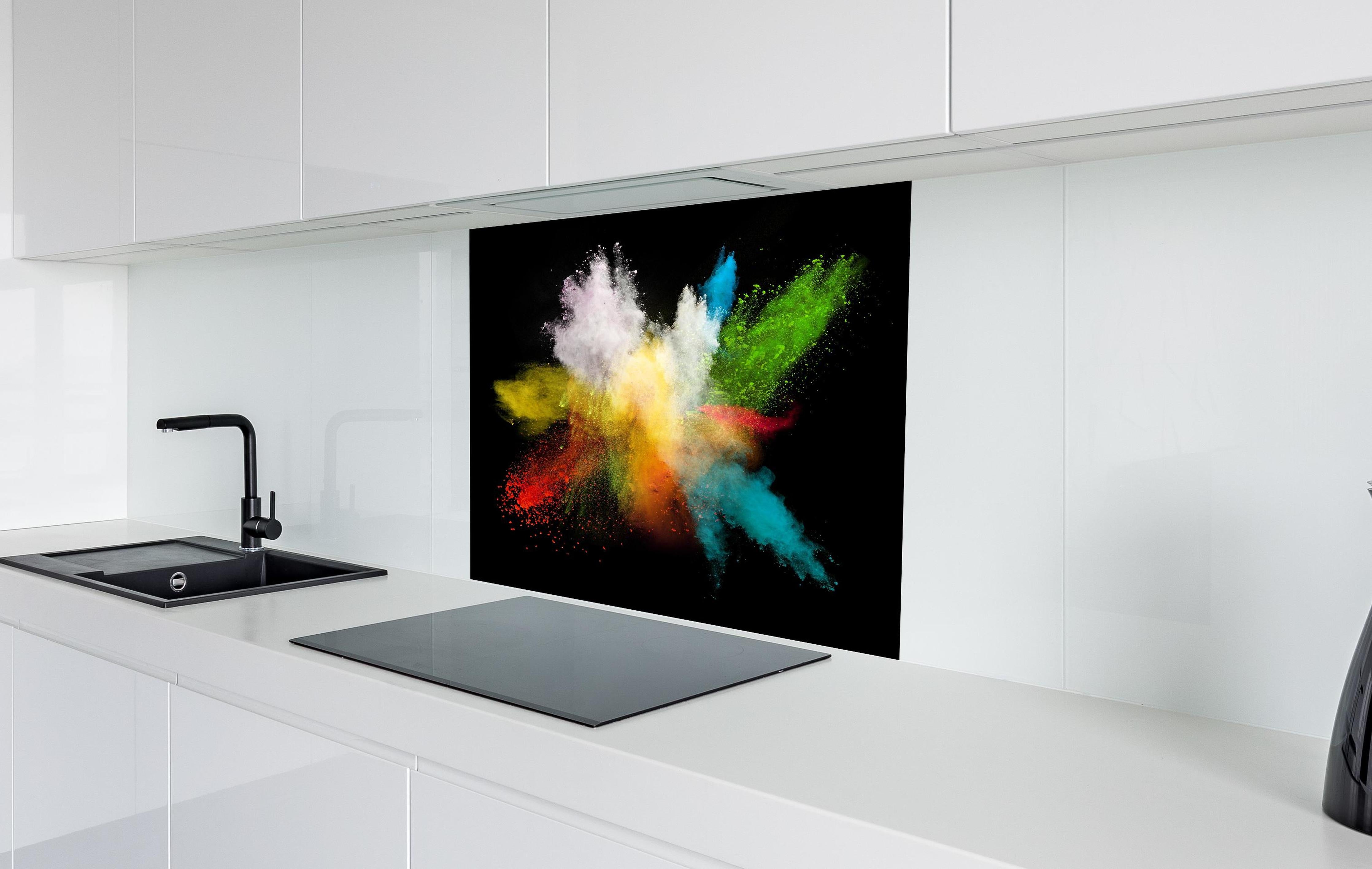 Spritzschutz - Bunte Farbexplosion auf schwarzem Hintergrund hinter einem Cerankochfeld zwischen Holz-Kochutensilien