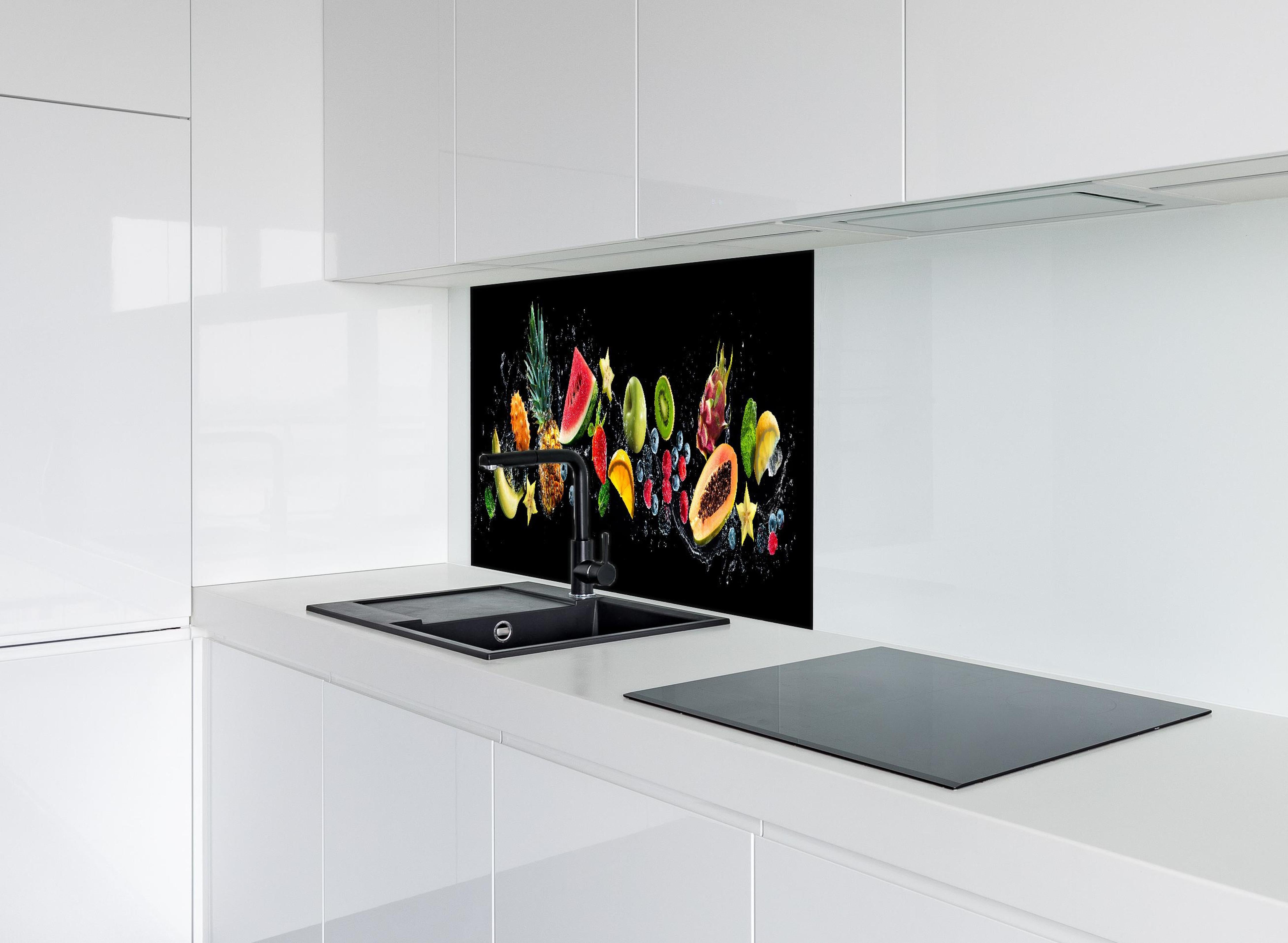 Spritzschutz - Bunte Früchte mit Wasserspritzern hinter einem Cerankochfeld zwischen Holz-Kochutensilien