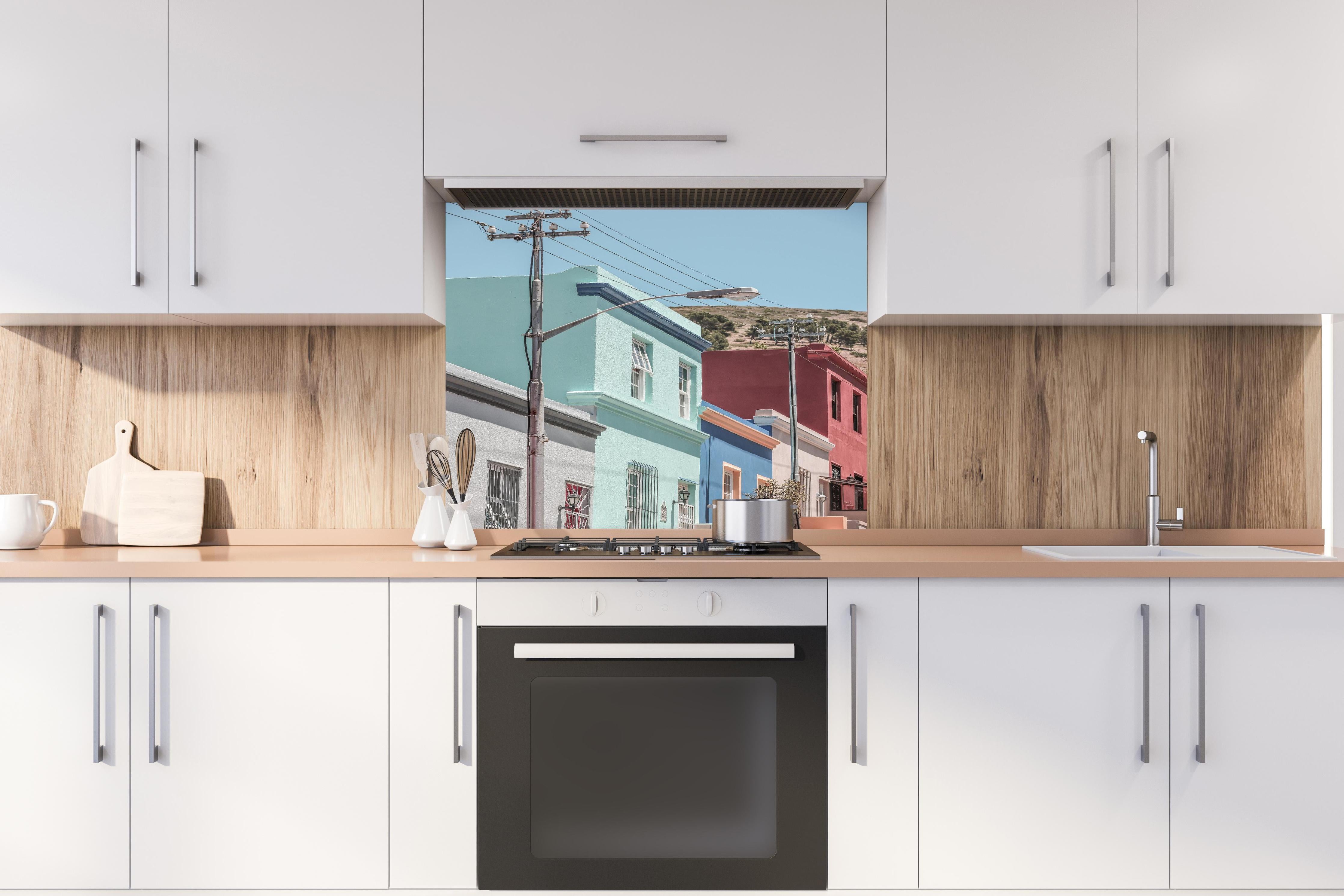 Spritzschutz - Bunte Gebäude - Bo-Kaap, Kapstadt hinter einem Cerankochfeld zwischen Holz-Kochutensilien