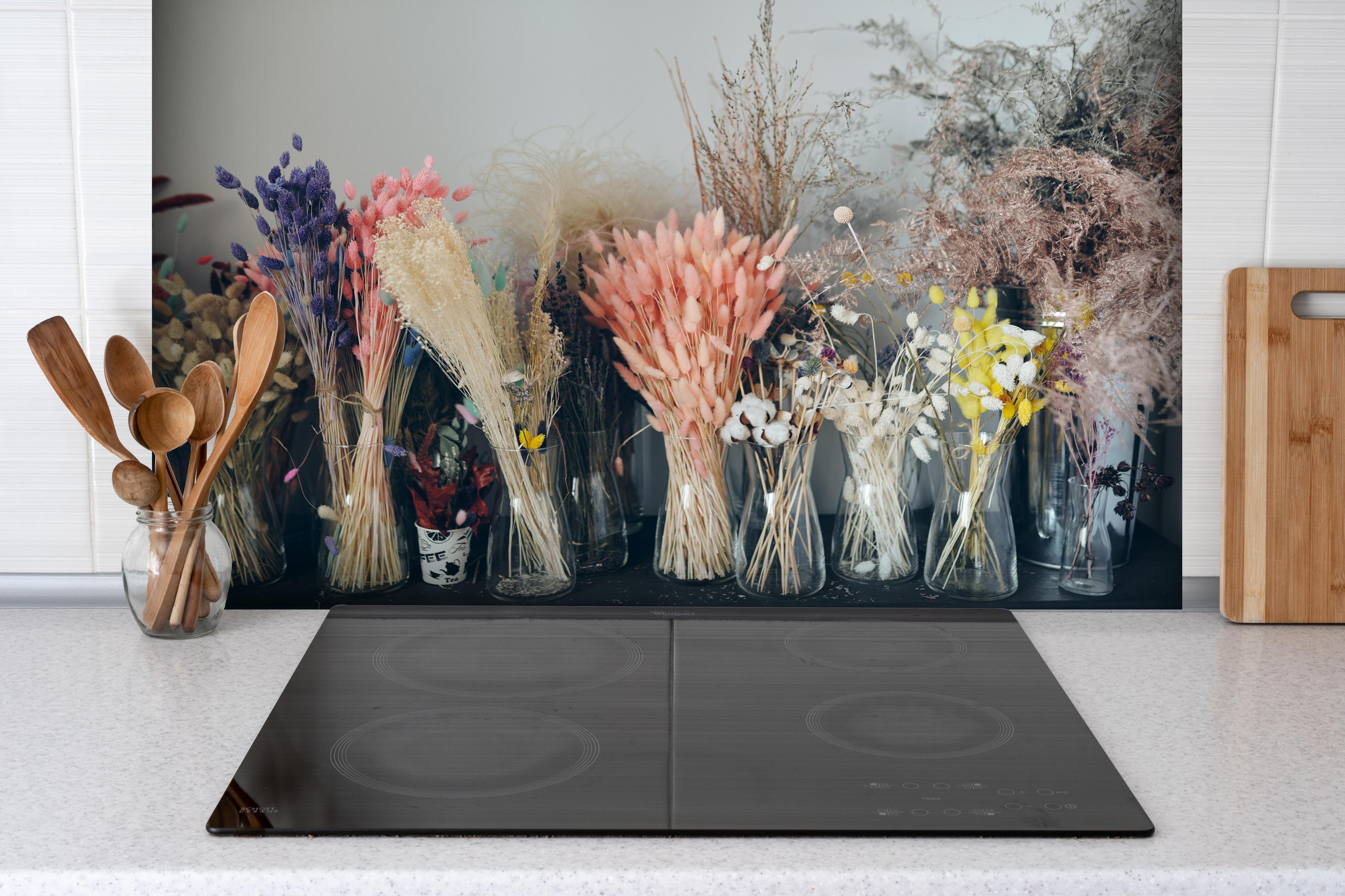 Spritzschutz - Bunte Trockenblumen im Regal hinter einem Cerankochfeld zwischen Holz-Kochutensilien