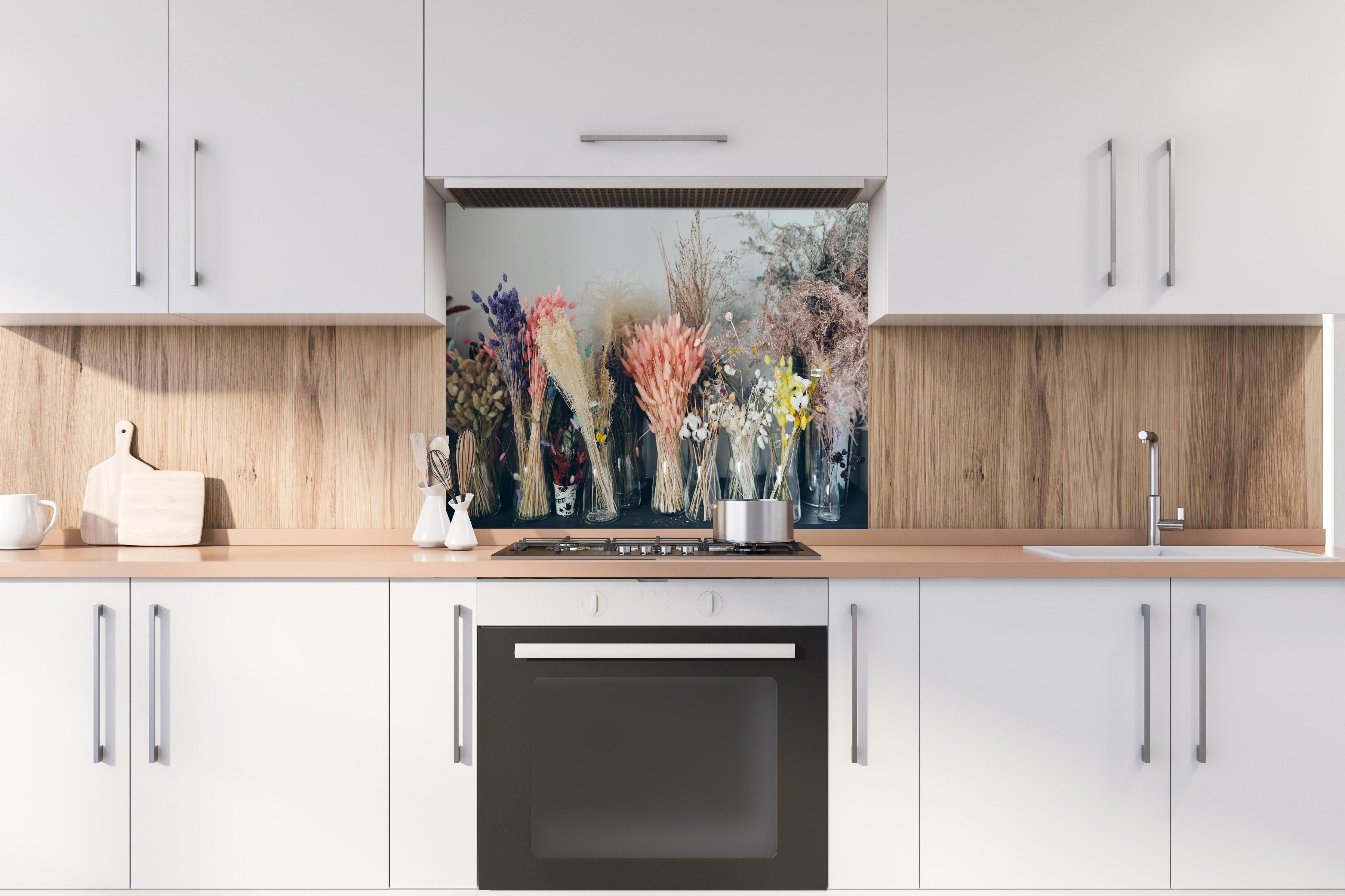 Spritzschutz - Bunte Trockenblumen im Regal hinter einem Cerankochfeld zwischen Holz-Kochutensilien