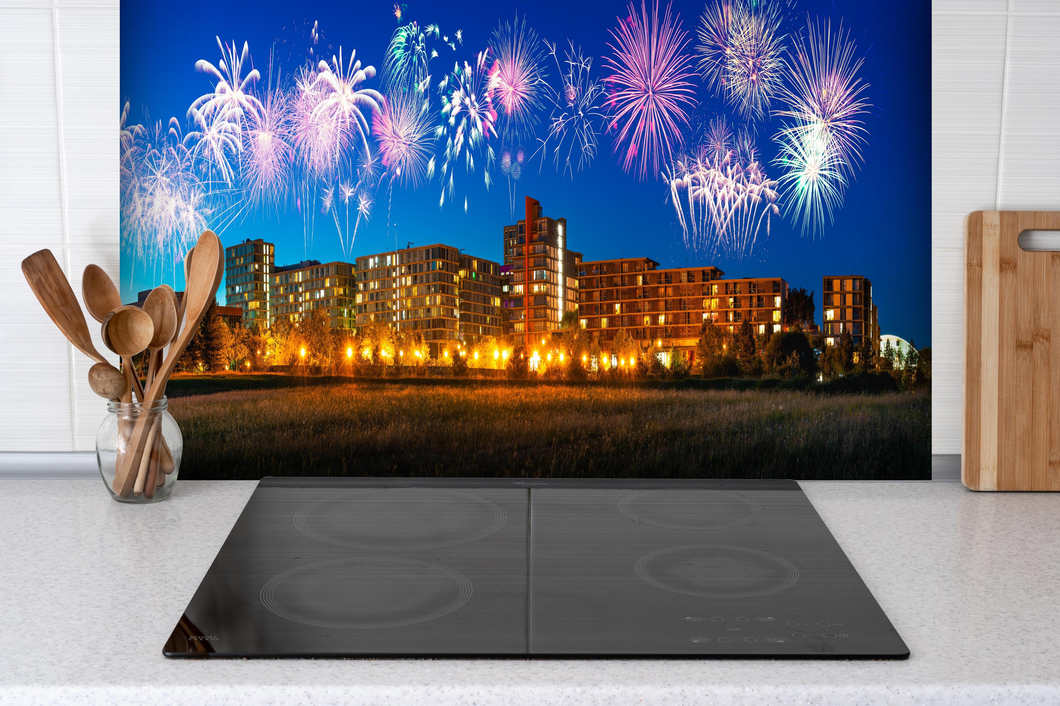 Spritzschutz - Buntes Feuerwerk Milton Keynes Skyline hinter einem Cerankochfeld zwischen Holz-Kochutensilien