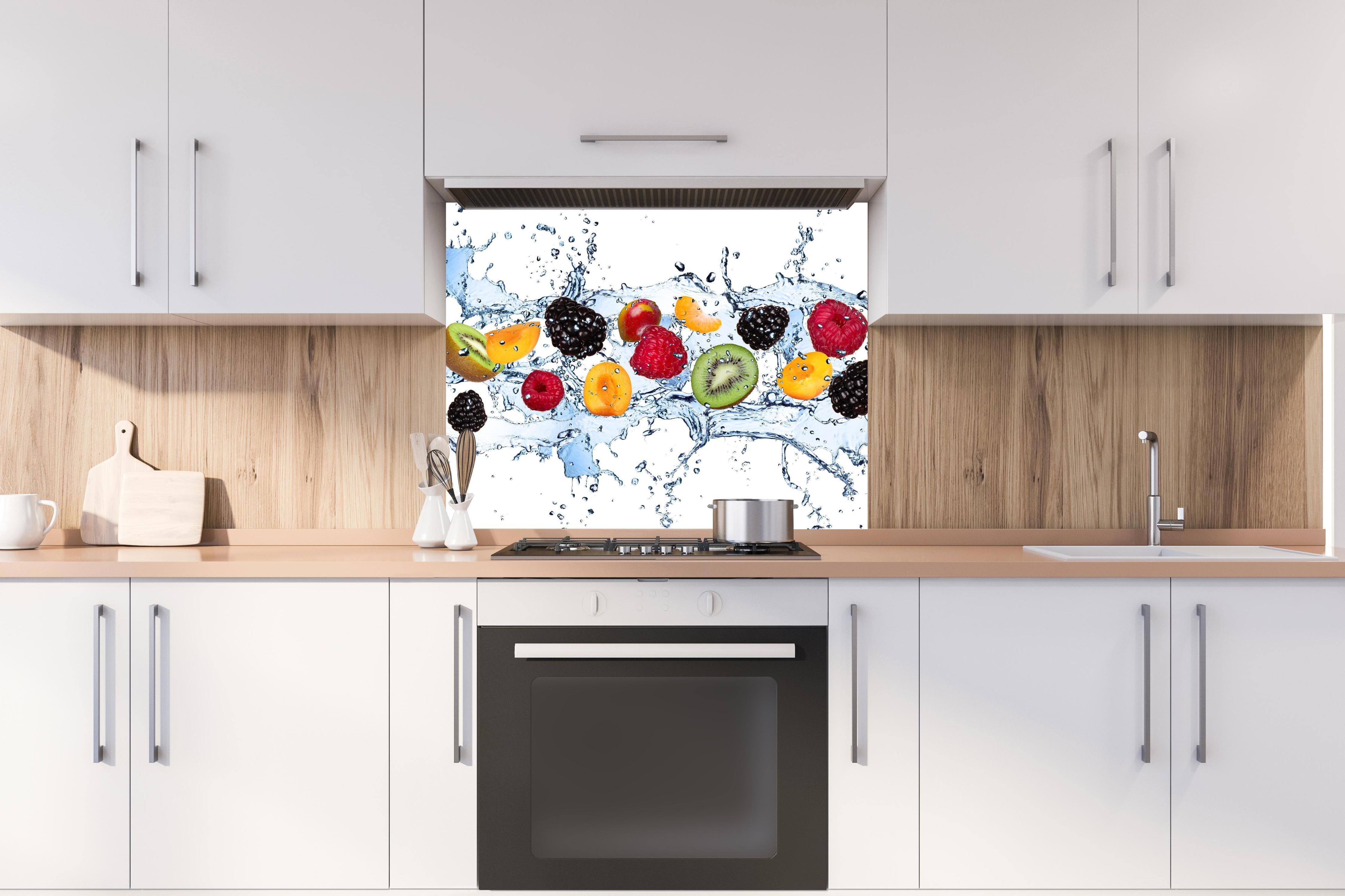 Spritzschutz - Buntes Fruchtwasser-Splash Fotografie hinter einem Cerankochfeld zwischen Holz-Kochutensilien