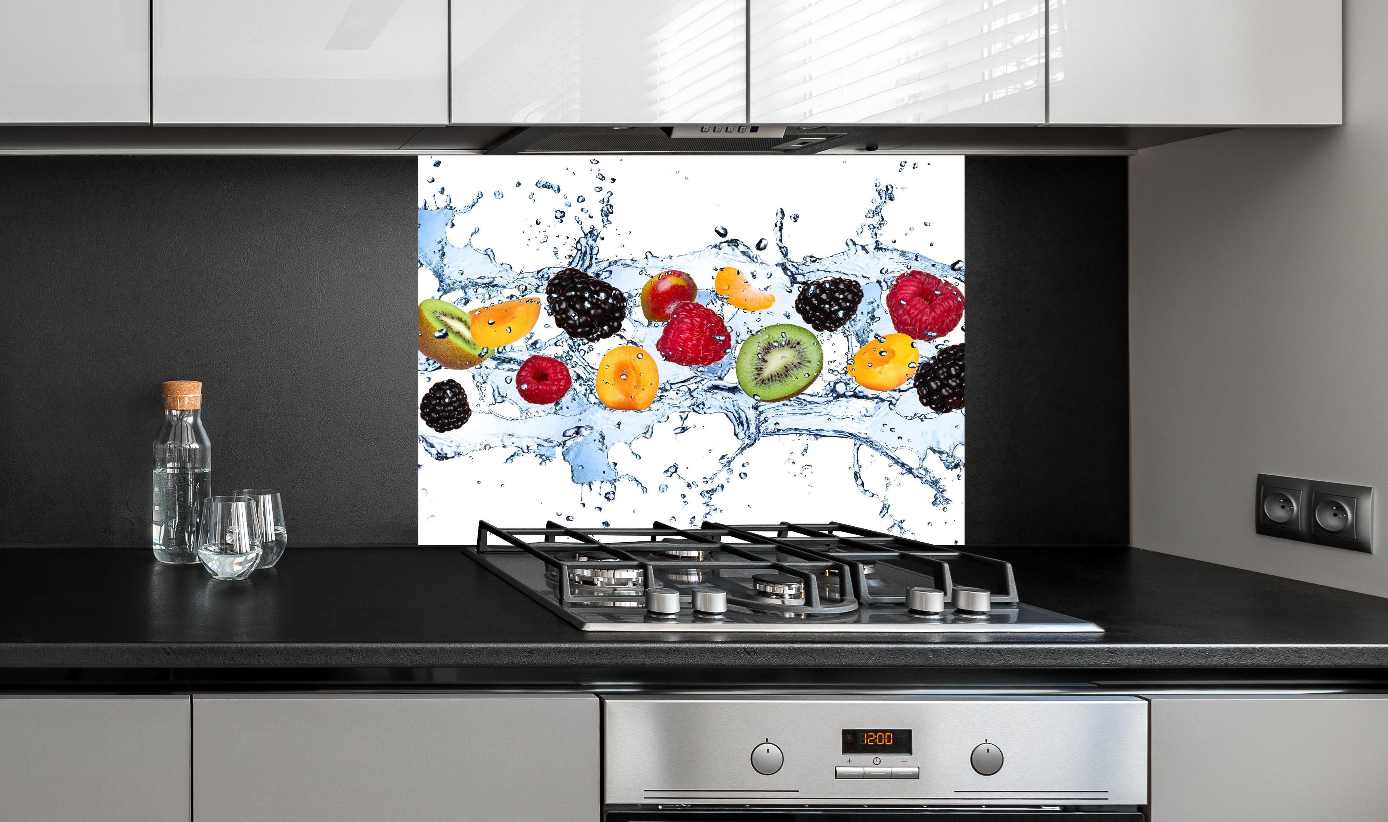 Spritzschutz - Buntes Fruchtwasser-Splash Fotografie hinter einem Cerankochfeld zwischen Holz-Kochutensilien