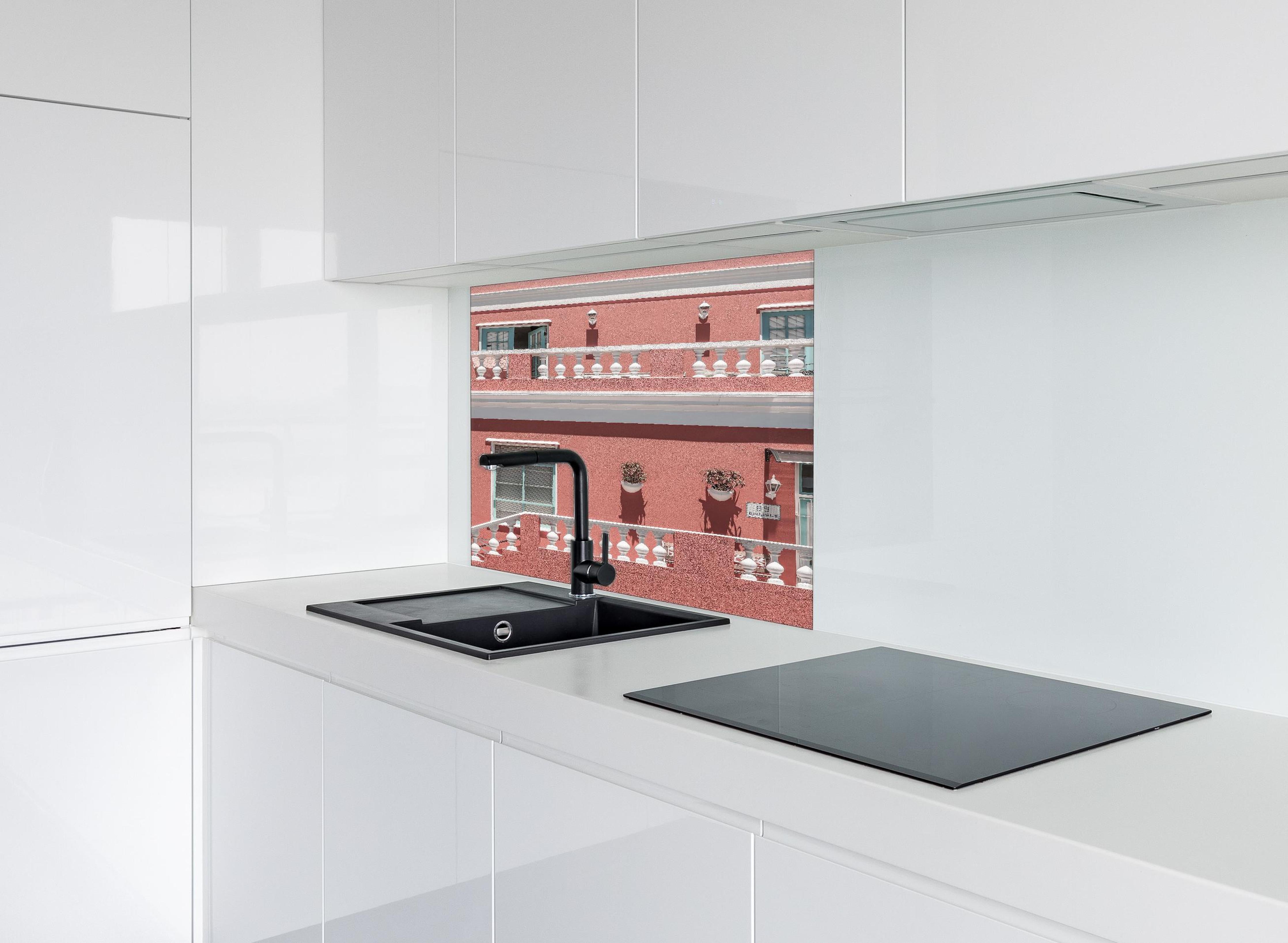 Spritzschutz - Buntes Gebäude mit pinker Fassade hinter einem Cerankochfeld zwischen Holz-Kochutensilien