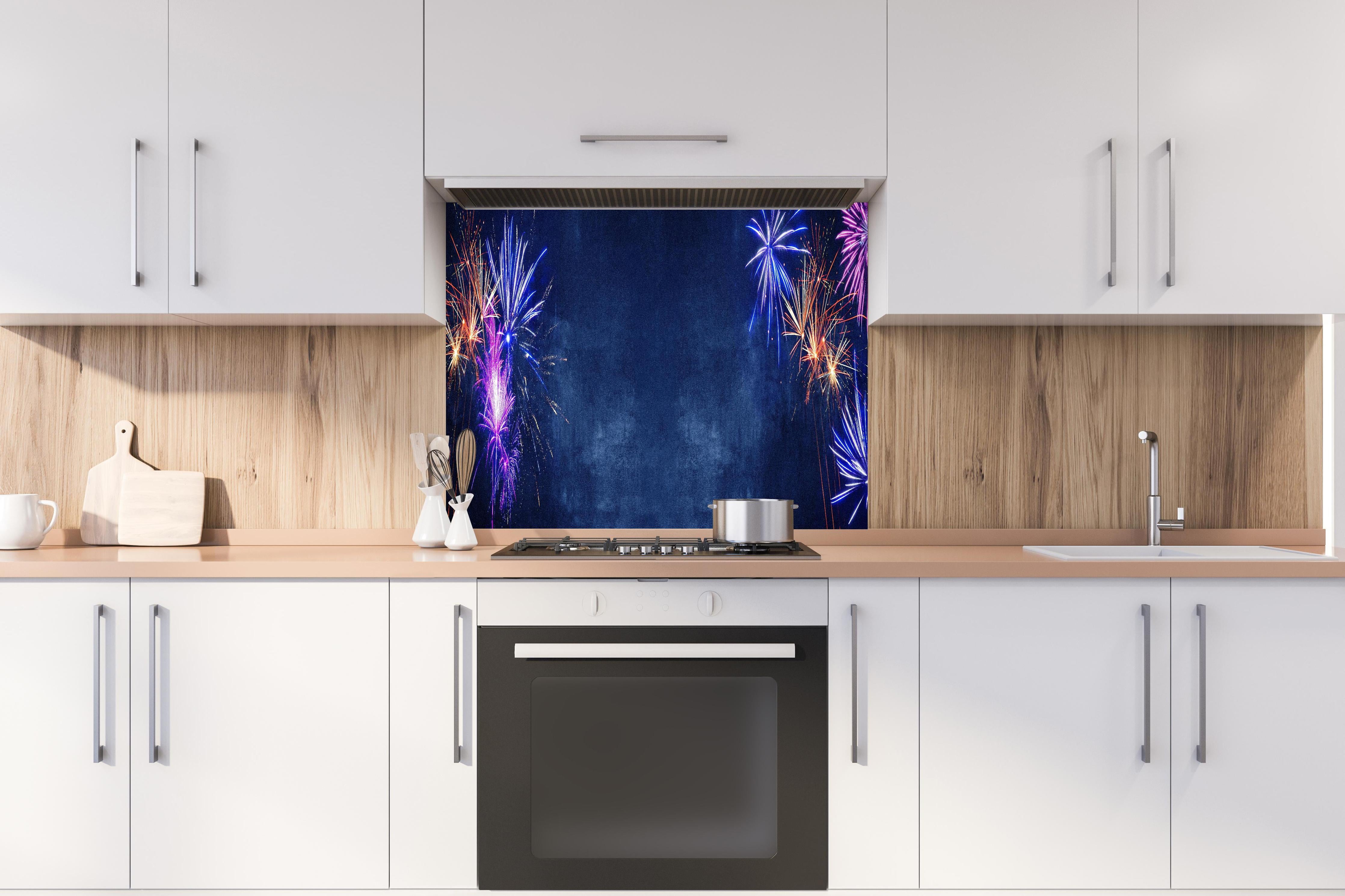 Spritzschutz - Buntes Silvester-Feuerwerk am Dunkelblauen Himmel hinter einem Cerankochfeld zwischen Holz-Kochutensilien