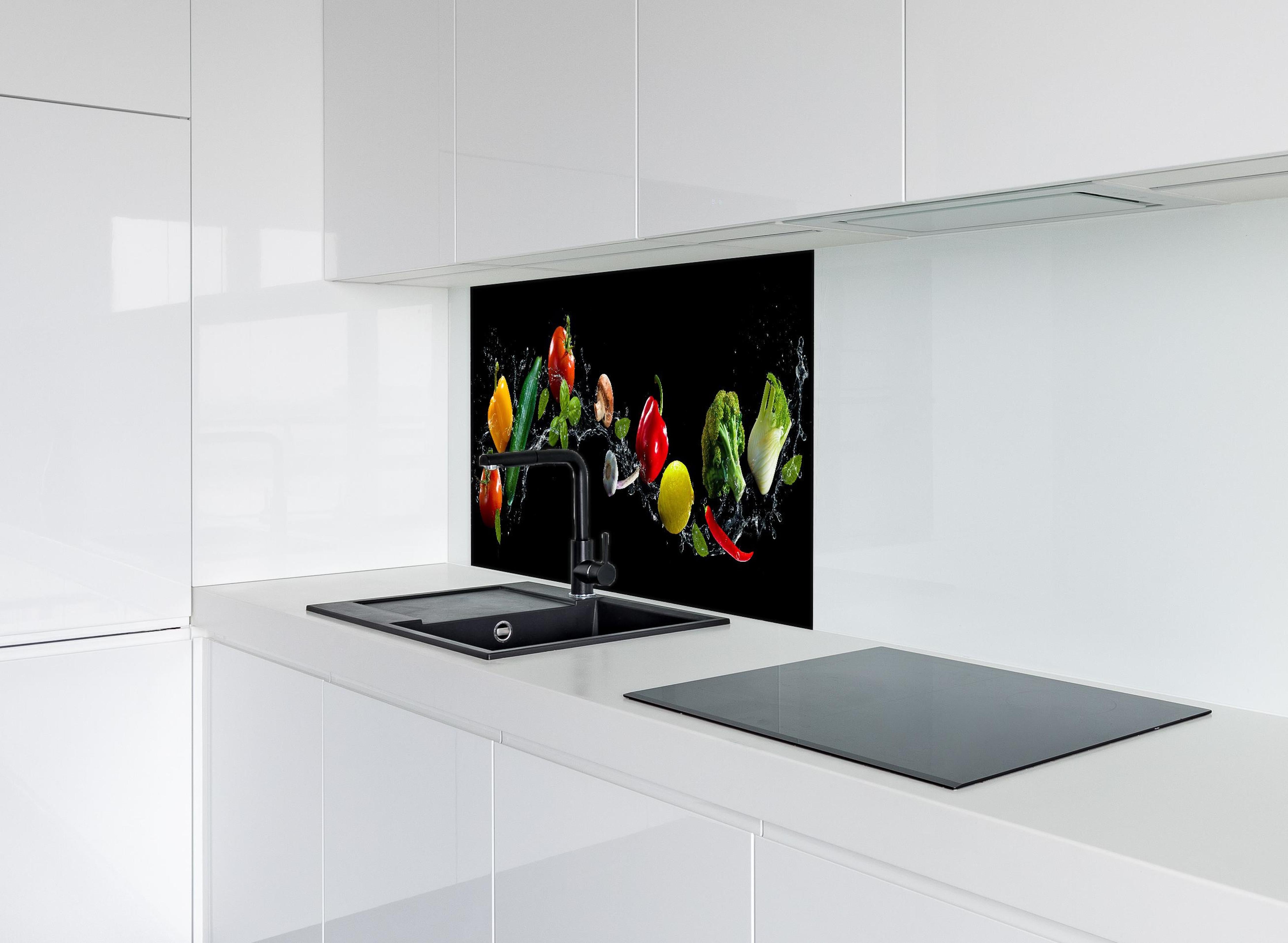 Spritzschutz - Buntes Spritzwasser-Gemüse auf Schwarz hinter einem Cerankochfeld zwischen Holz-Kochutensilien