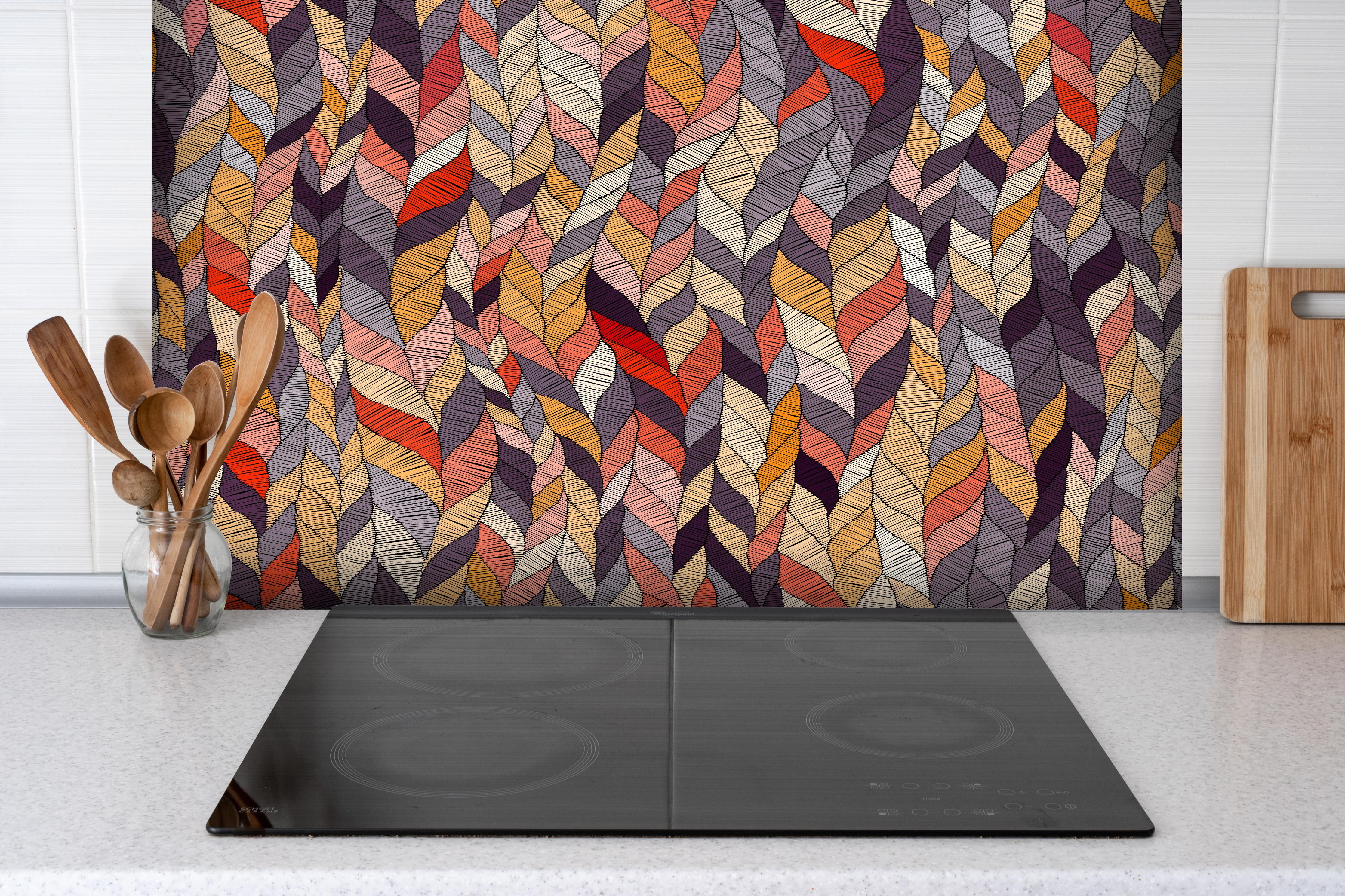 Spritzschutz - Buntes Textil Wellenmuster in Herbsttönen hinter einem Cerankochfeld zwischen Holz-Kochutensilien