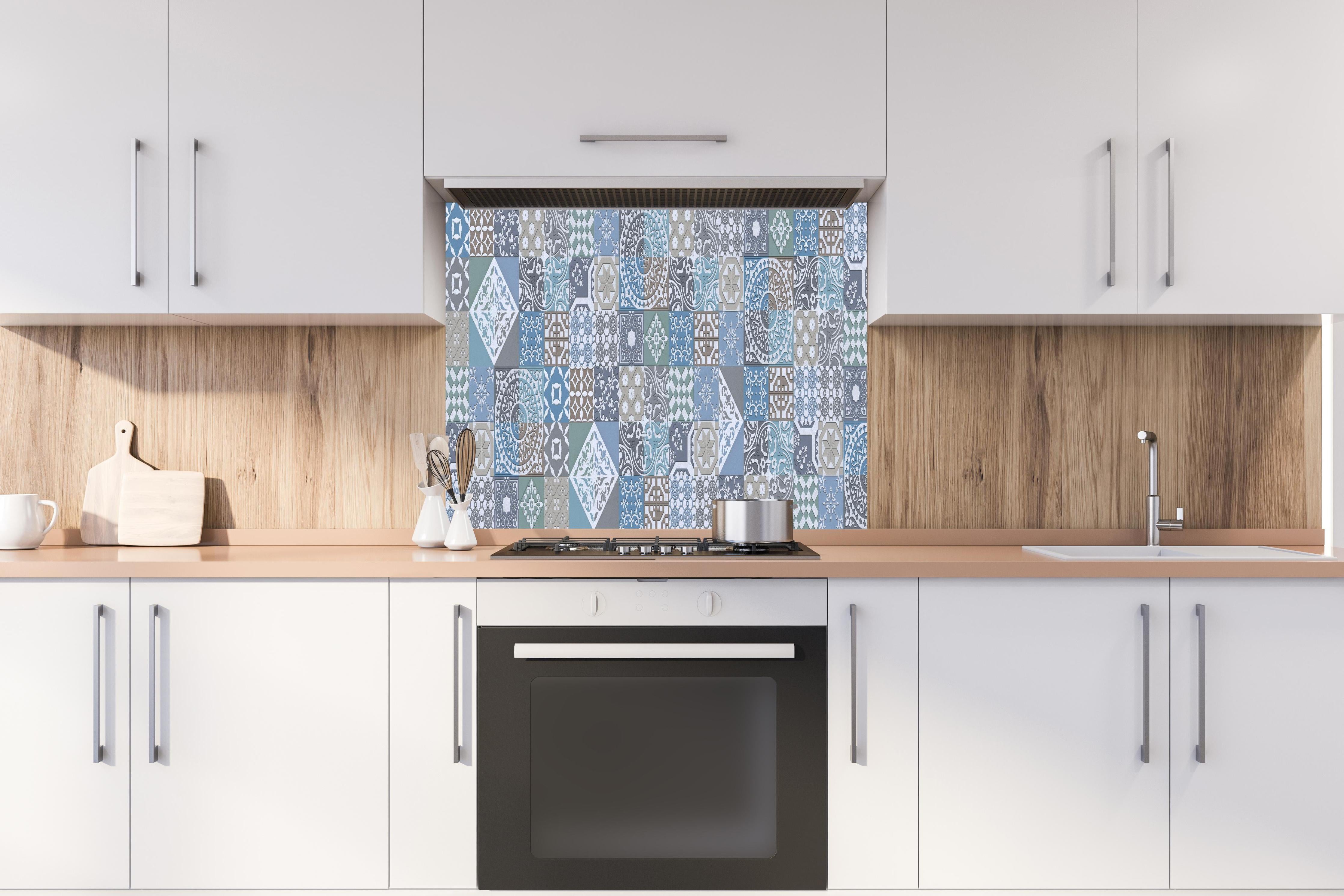 Spritzschutz - Buntes portugiesisches Mosaik hinter einem Cerankochfeld zwischen Holz-Kochutensilien