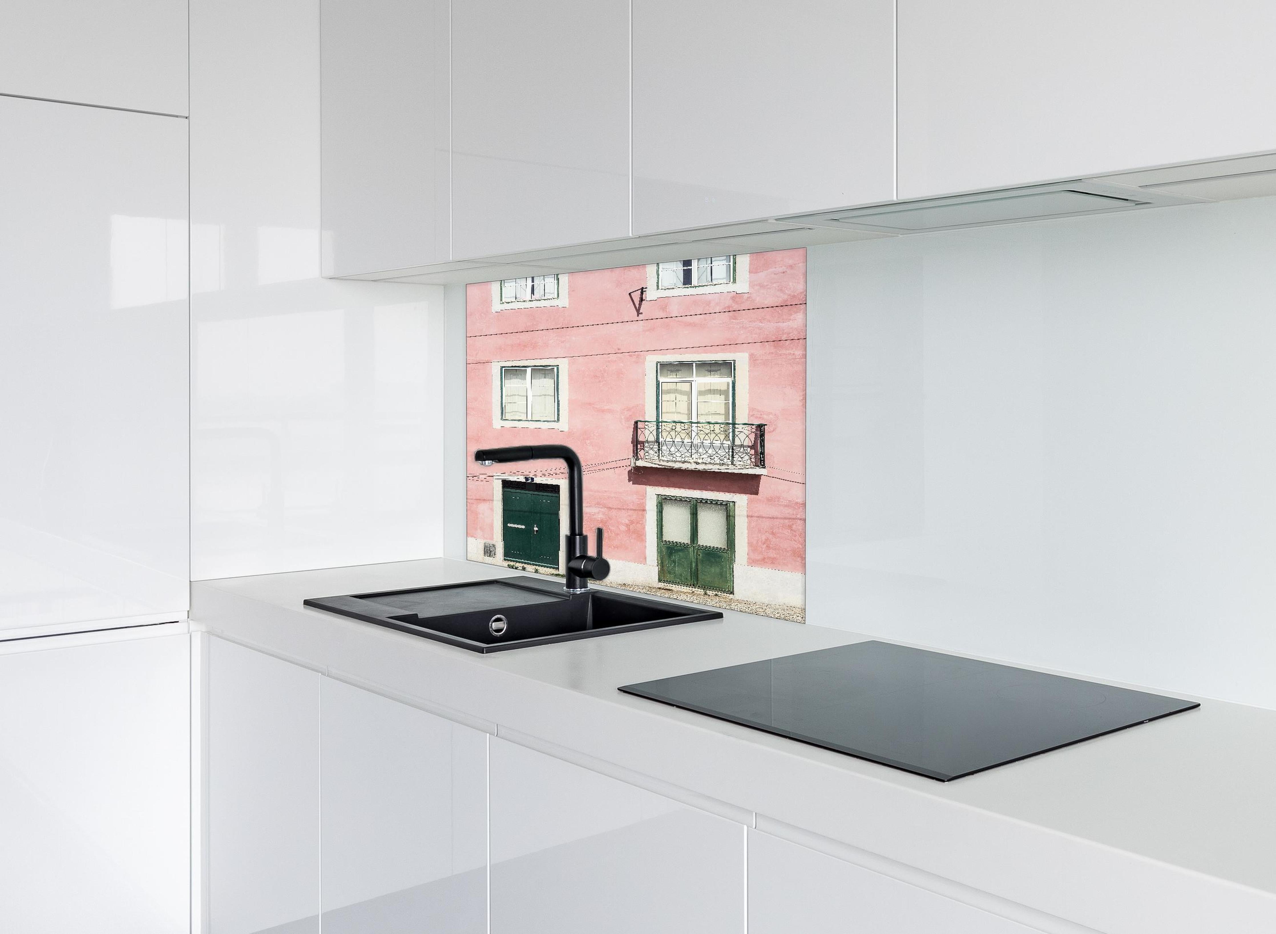 Spritzschutz - Charmante Pastellrosa Fassade mit Balkon hinter einem Cerankochfeld zwischen Holz-Kochutensilien