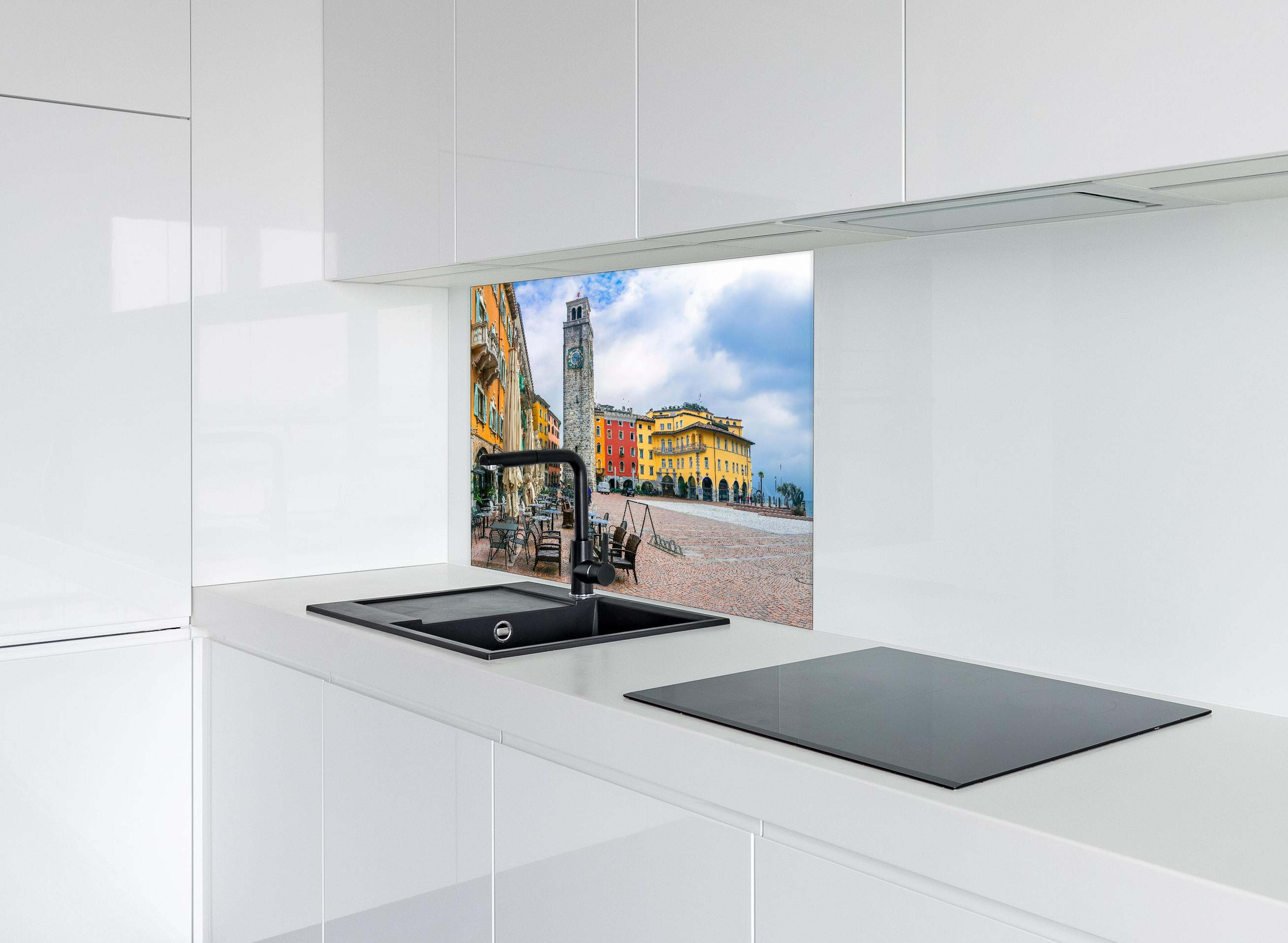 Spritzschutz - Charmante Stadt am Gardasee - Riva del Garda hinter einem Cerankochfeld zwischen Holz-Kochutensilien