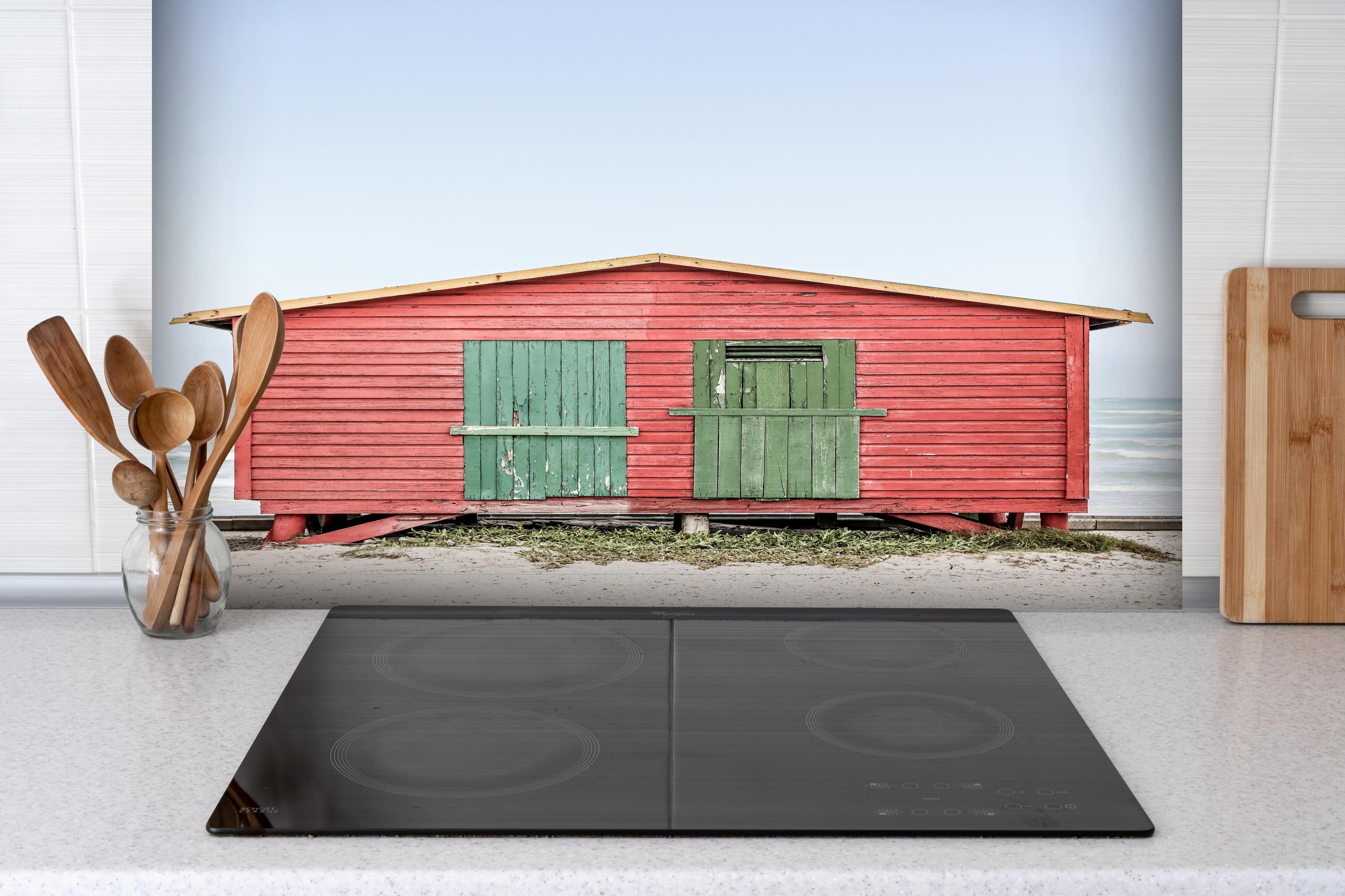 Spritzschutz - Charmante rote Strandhütte Küstenblick hinter einem Cerankochfeld zwischen Holz-Kochutensilien