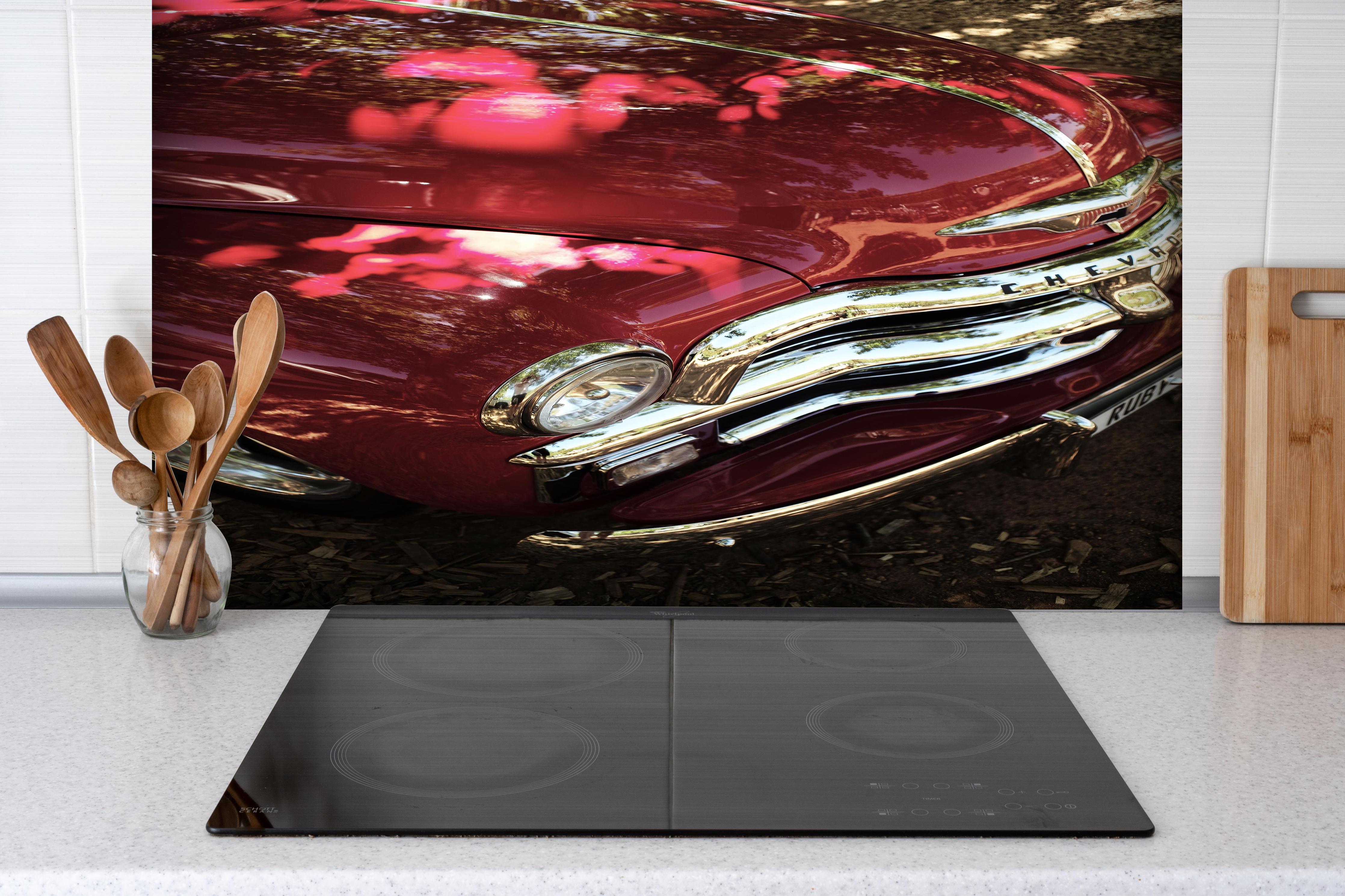 Spritzschutz - Chevrolet Nahaufnahme hinter einem Cerankochfeld zwischen Holz-Kochutensilien