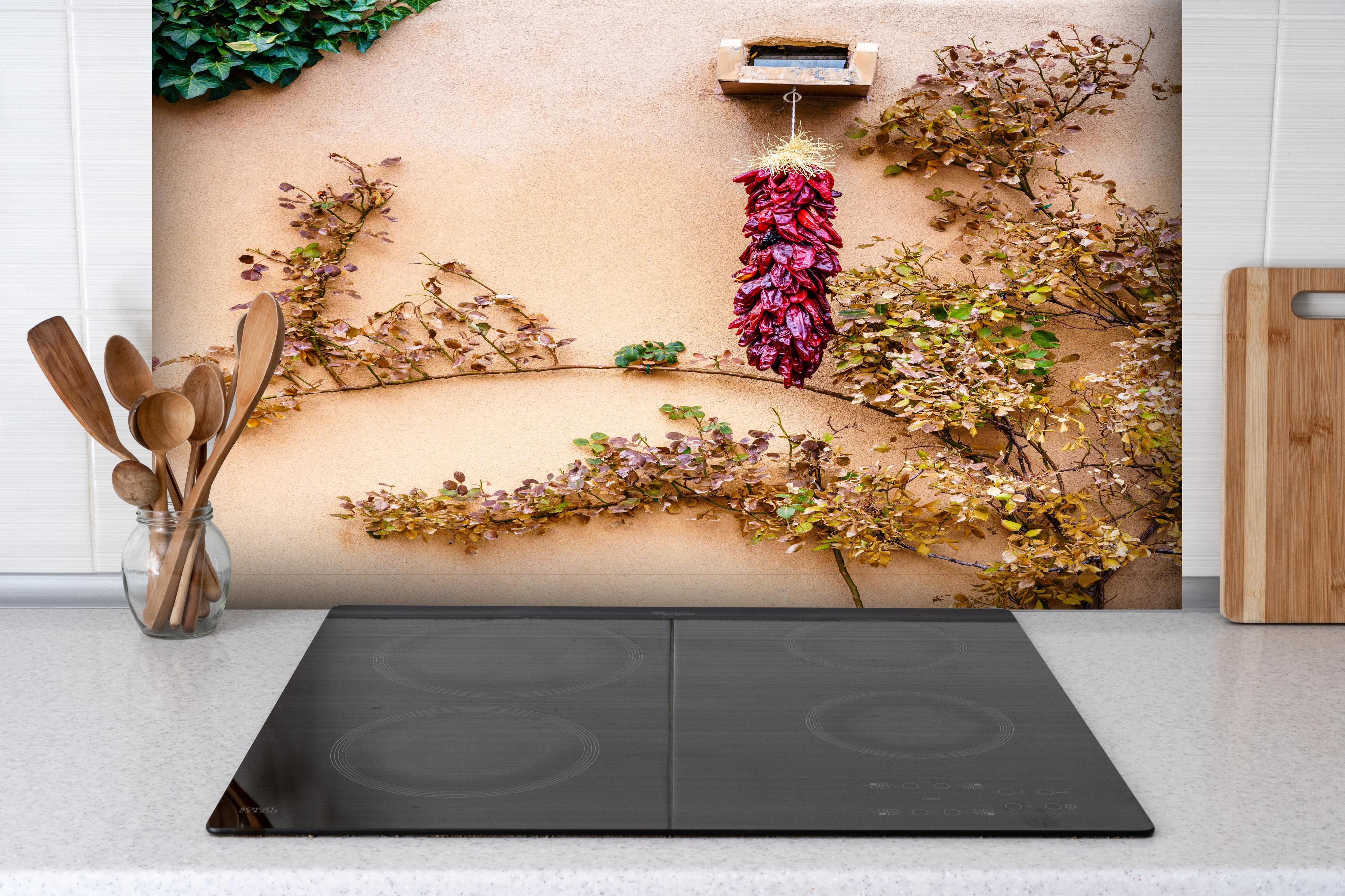 Spritzschutz - Chili Bündel - New Mexico hinter einem Cerankochfeld zwischen Holz-Kochutensilien