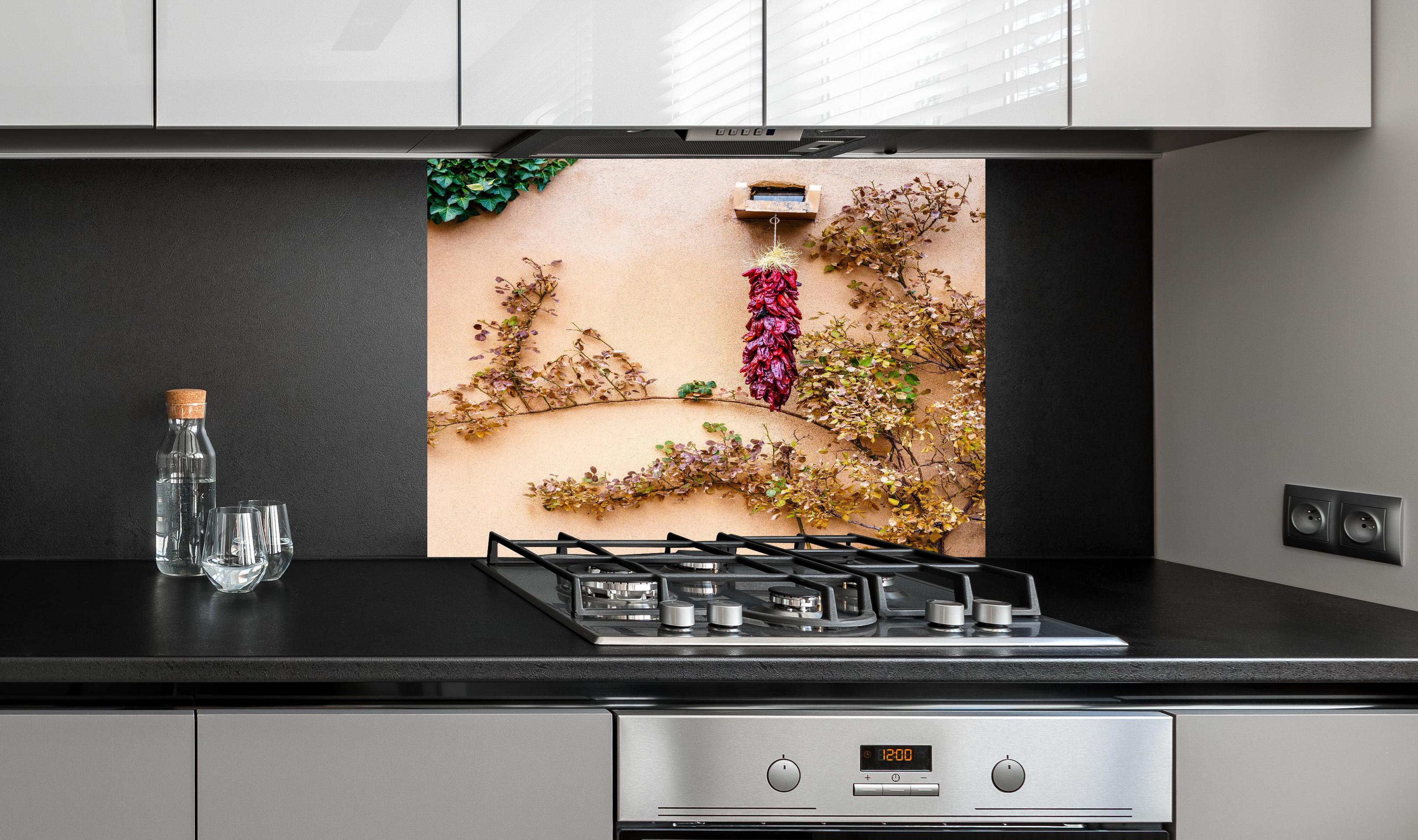 Spritzschutz - Chili Bündel - New Mexico hinter einem Cerankochfeld zwischen Holz-Kochutensilien