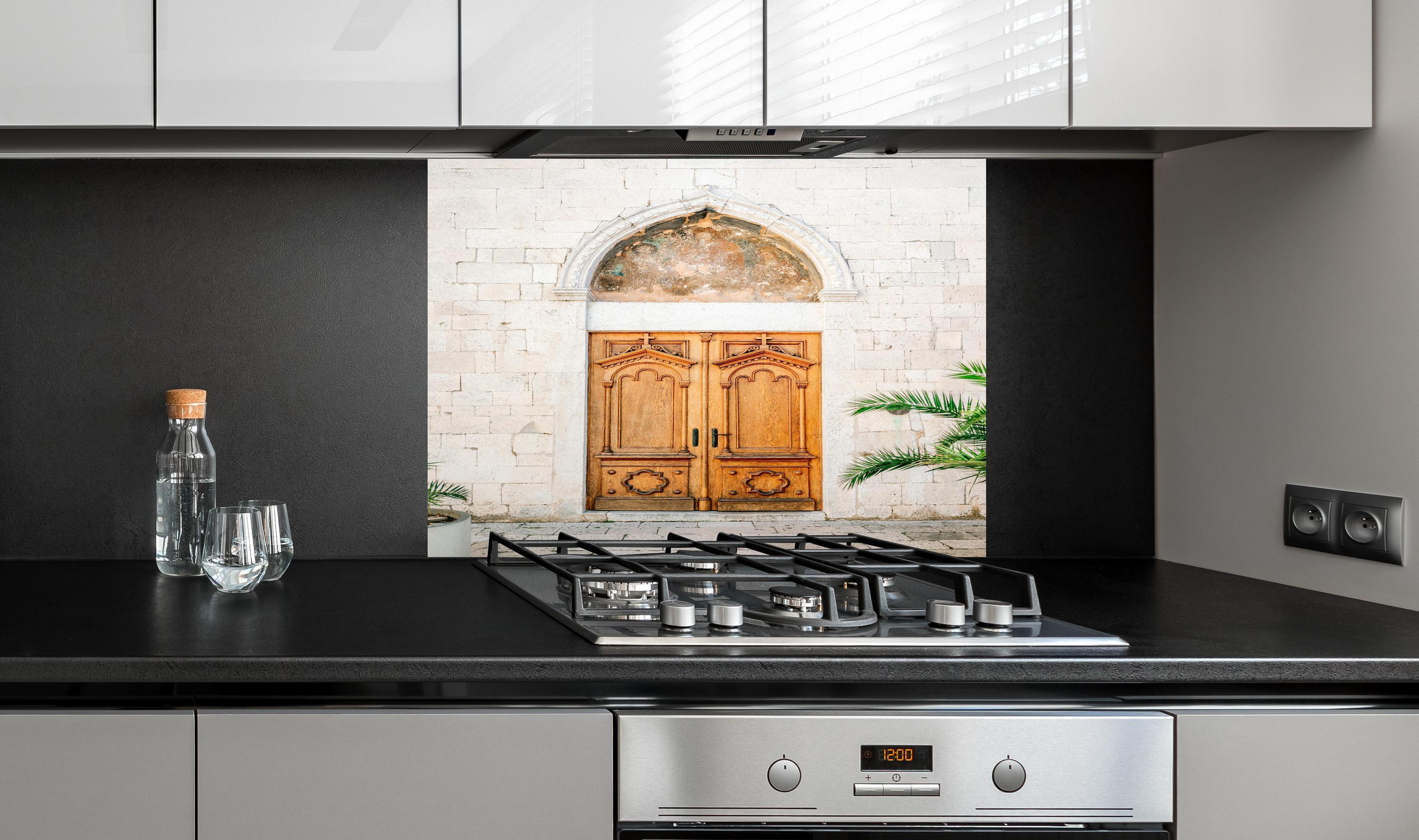 Spritzschutz - Croatian Door hinter einem Cerankochfeld zwischen Holz-Kochutensilien