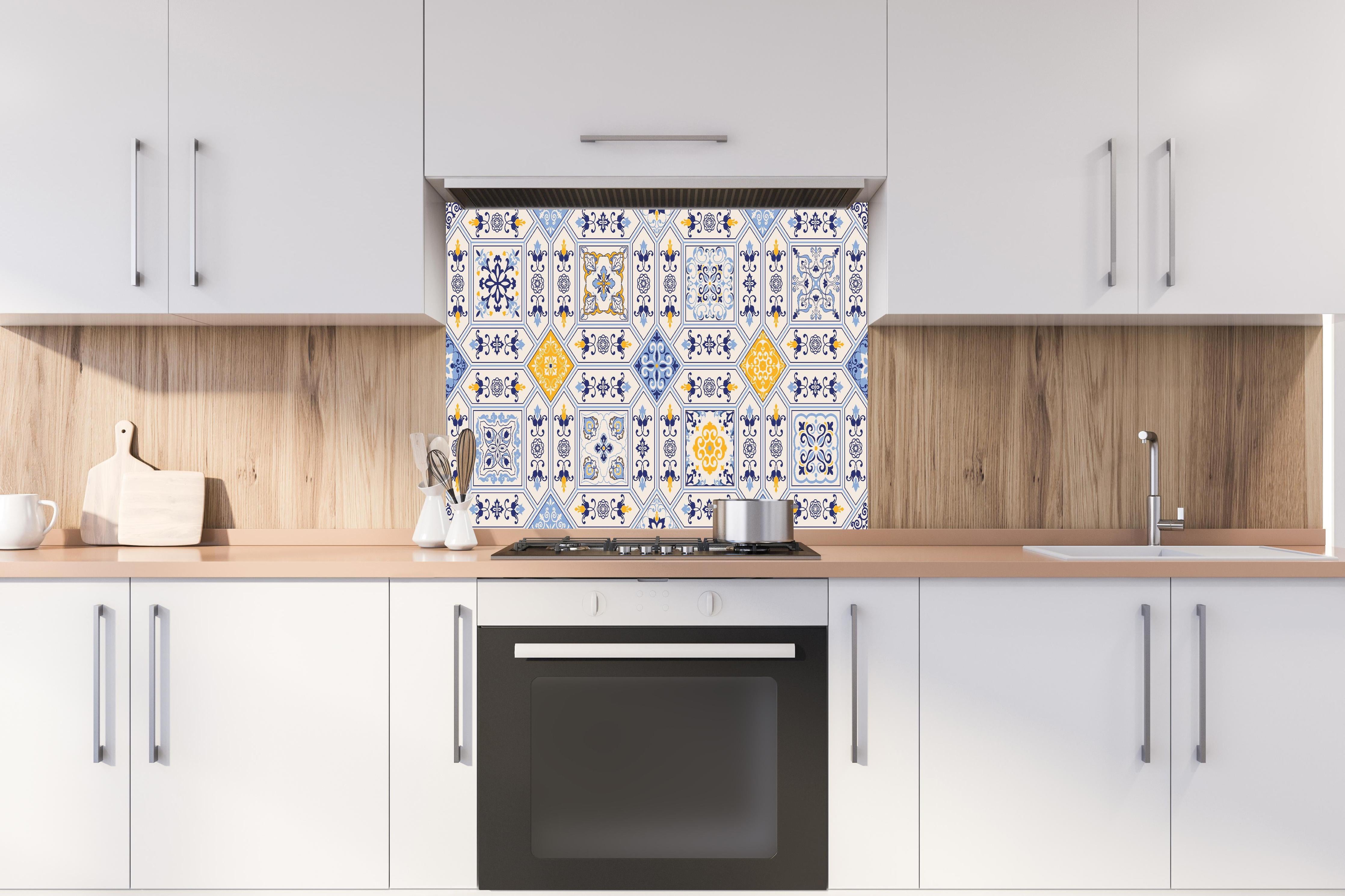 Spritzschutz - Dekorative Blau-Gelbe Keramikfliesen hinter einem Cerankochfeld zwischen Holz-Kochutensilien