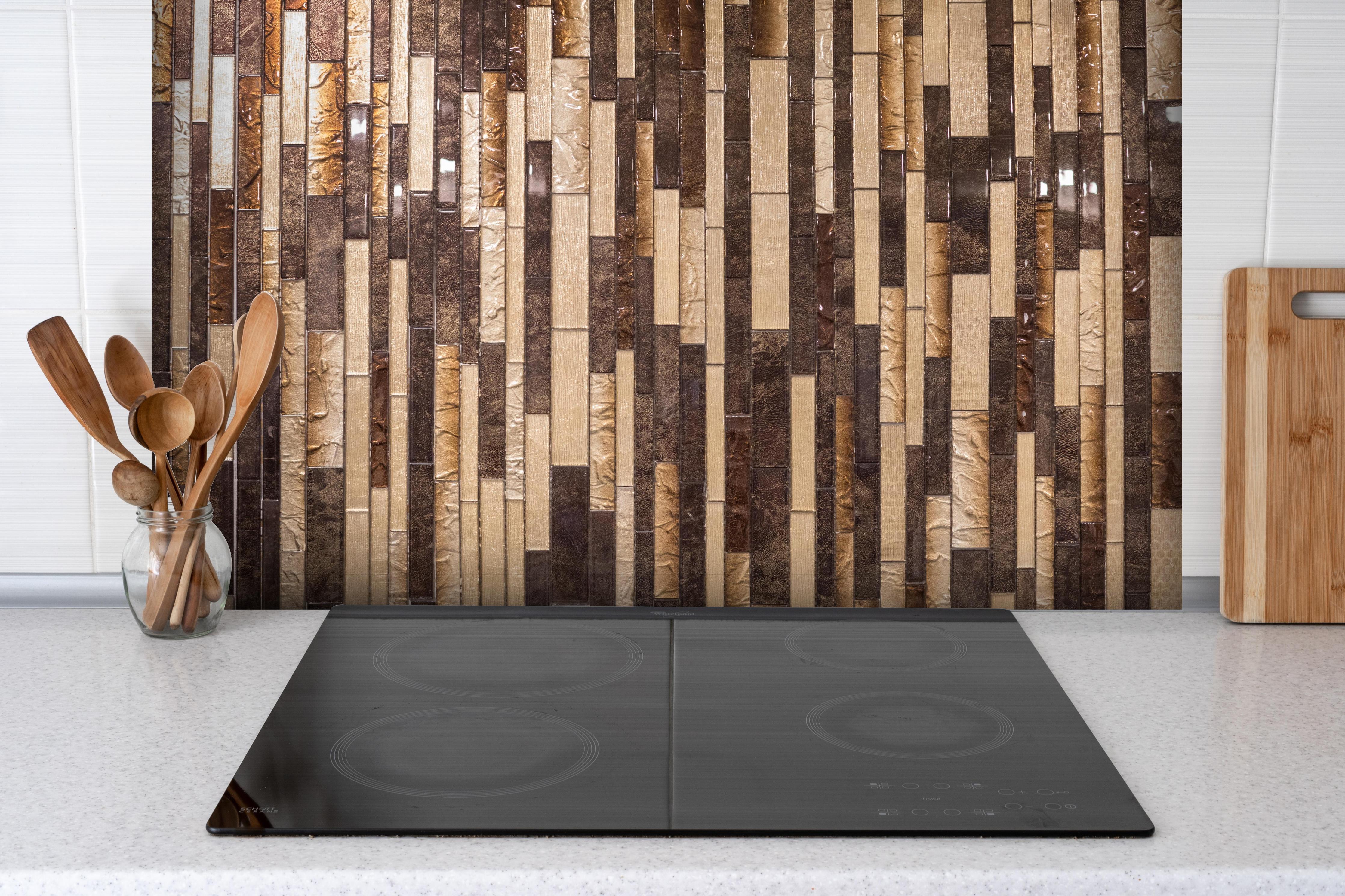 Spritzschutz - Dekorative Braun-Beige Mosaik-Holztextur hinter einem Cerankochfeld zwischen Holz-Kochutensilien