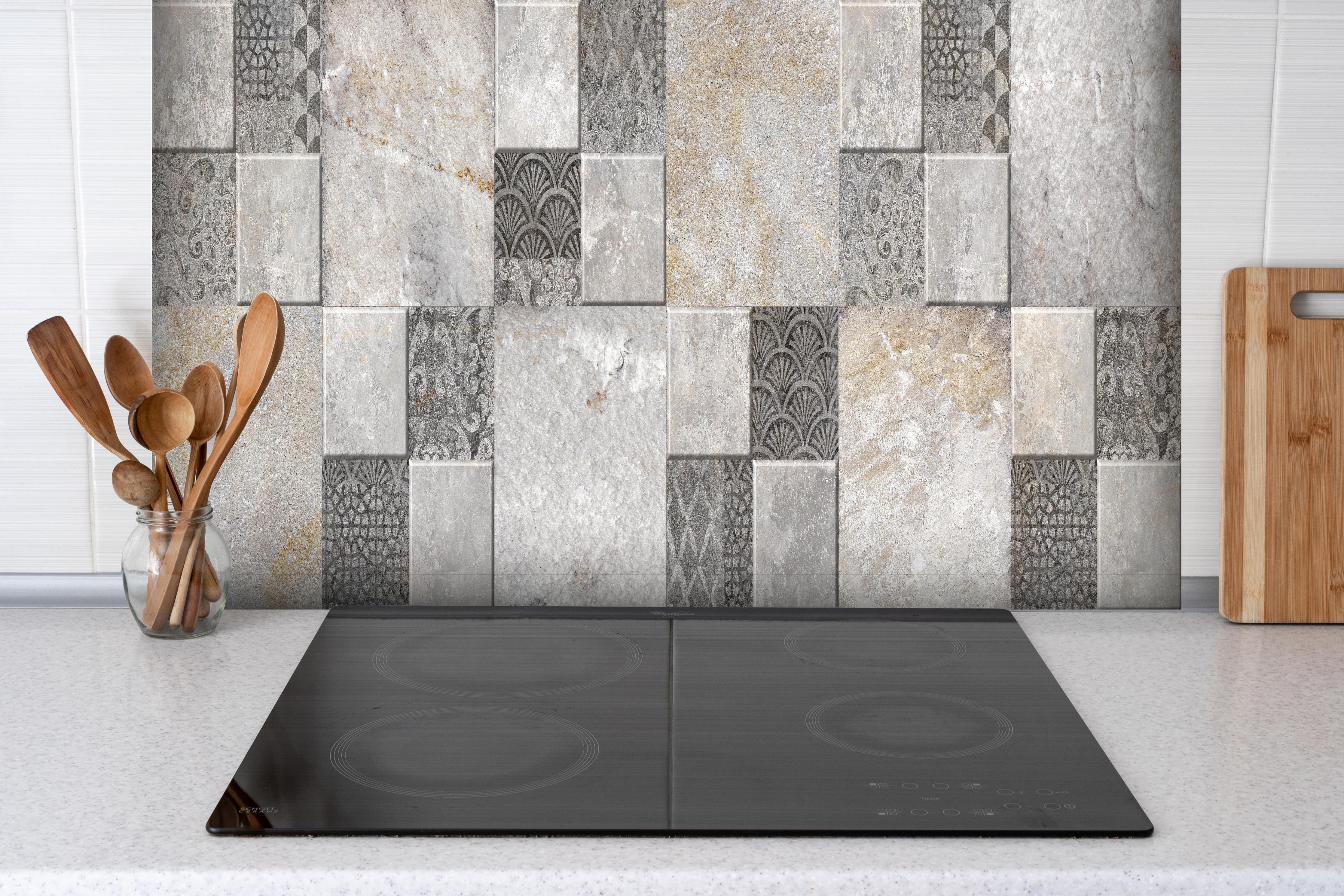 Spritzschutz - Dekorativer Steinmosaik hinter einem Cerankochfeld zwischen Holz-Kochutensilien