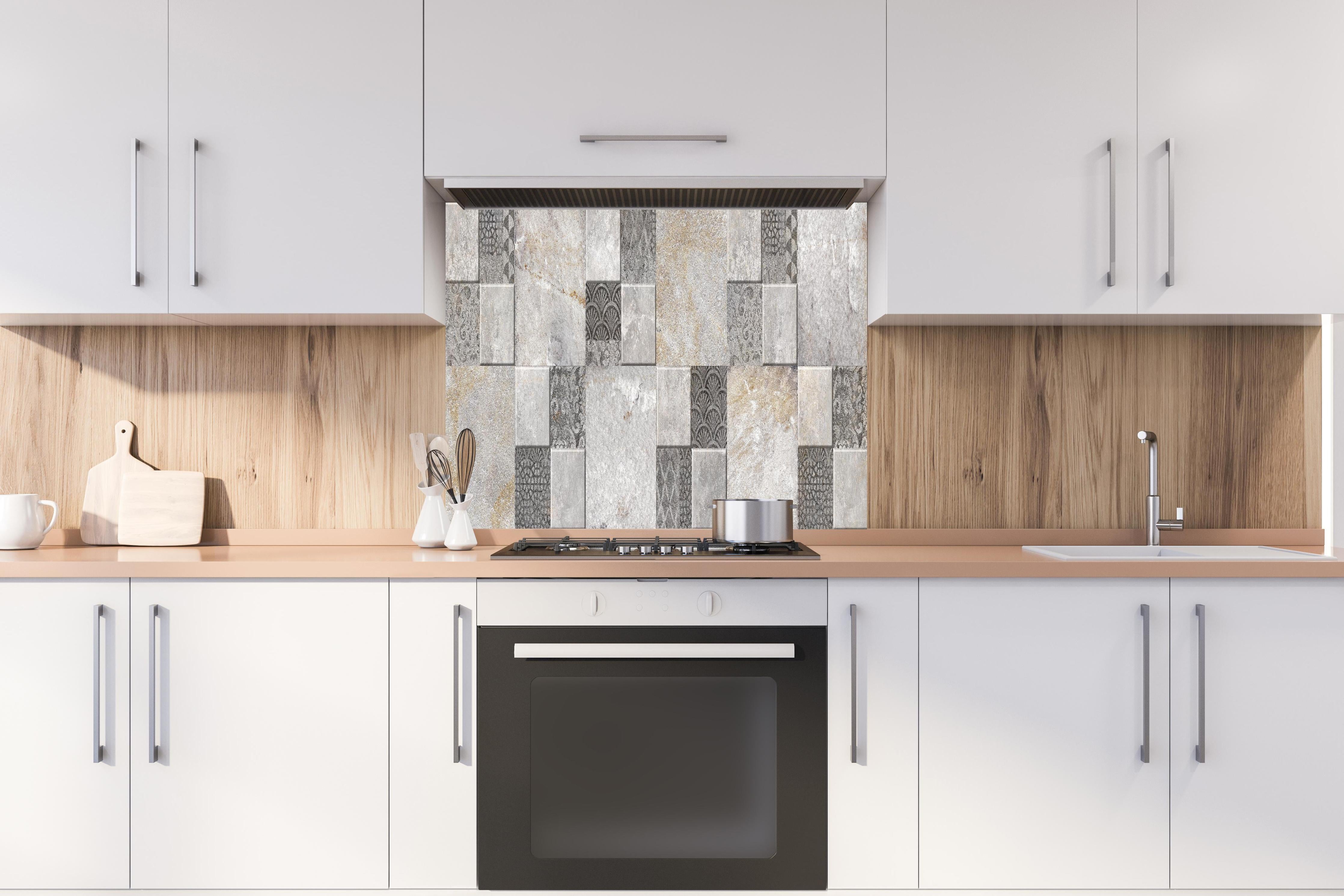 Spritzschutz - Dekorativer Steinmosaik hinter einem Cerankochfeld zwischen Holz-Kochutensilien