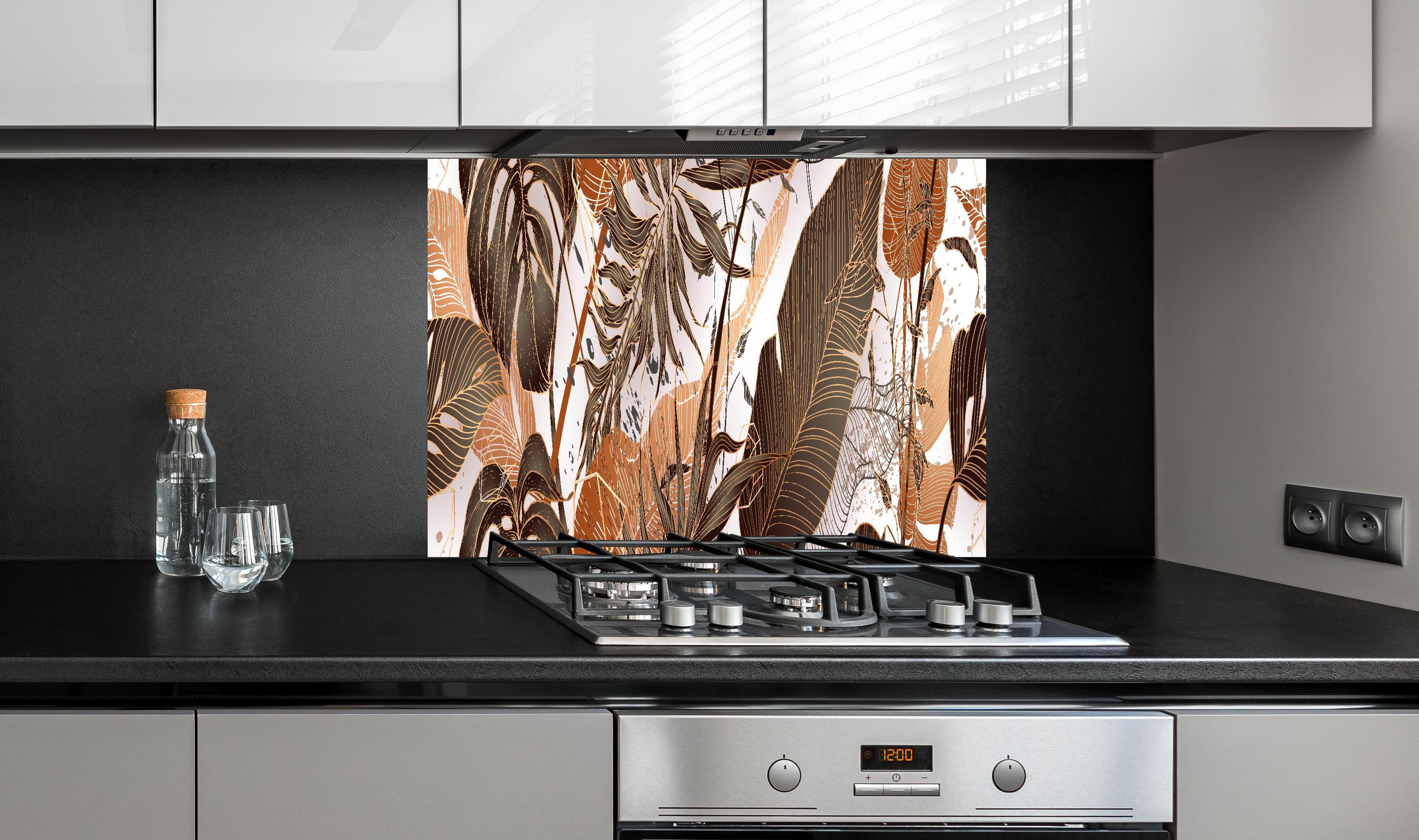 Spritzschutz - Dekoratives Blatt-Design in warmen Erdtönen hinter einem Cerankochfeld zwischen Holz-Kochutensilien