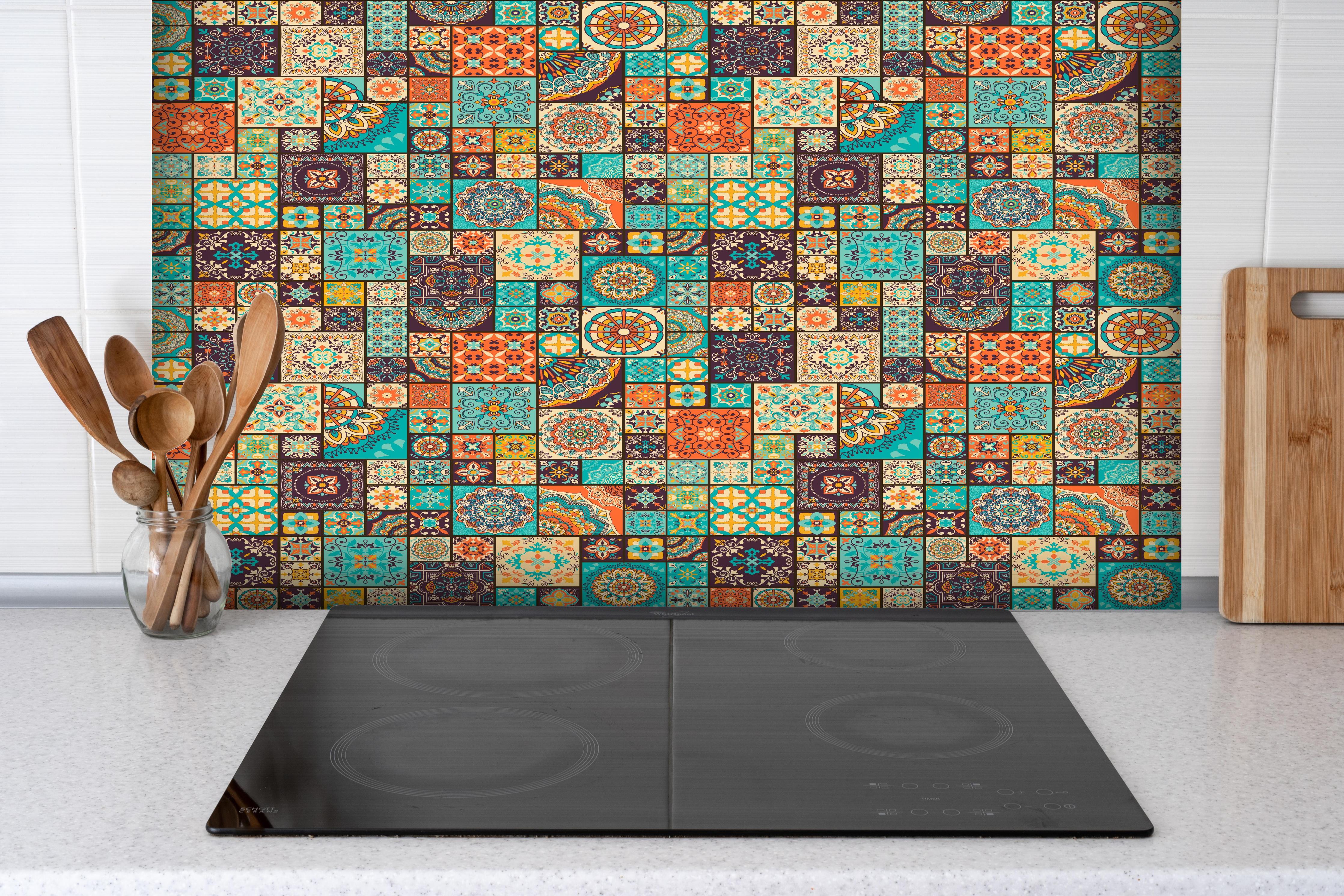Spritzschutz - Dekoratives buntes Patchwork-Fliesen-Design hinter einem Cerankochfeld zwischen Holz-Kochutensilien