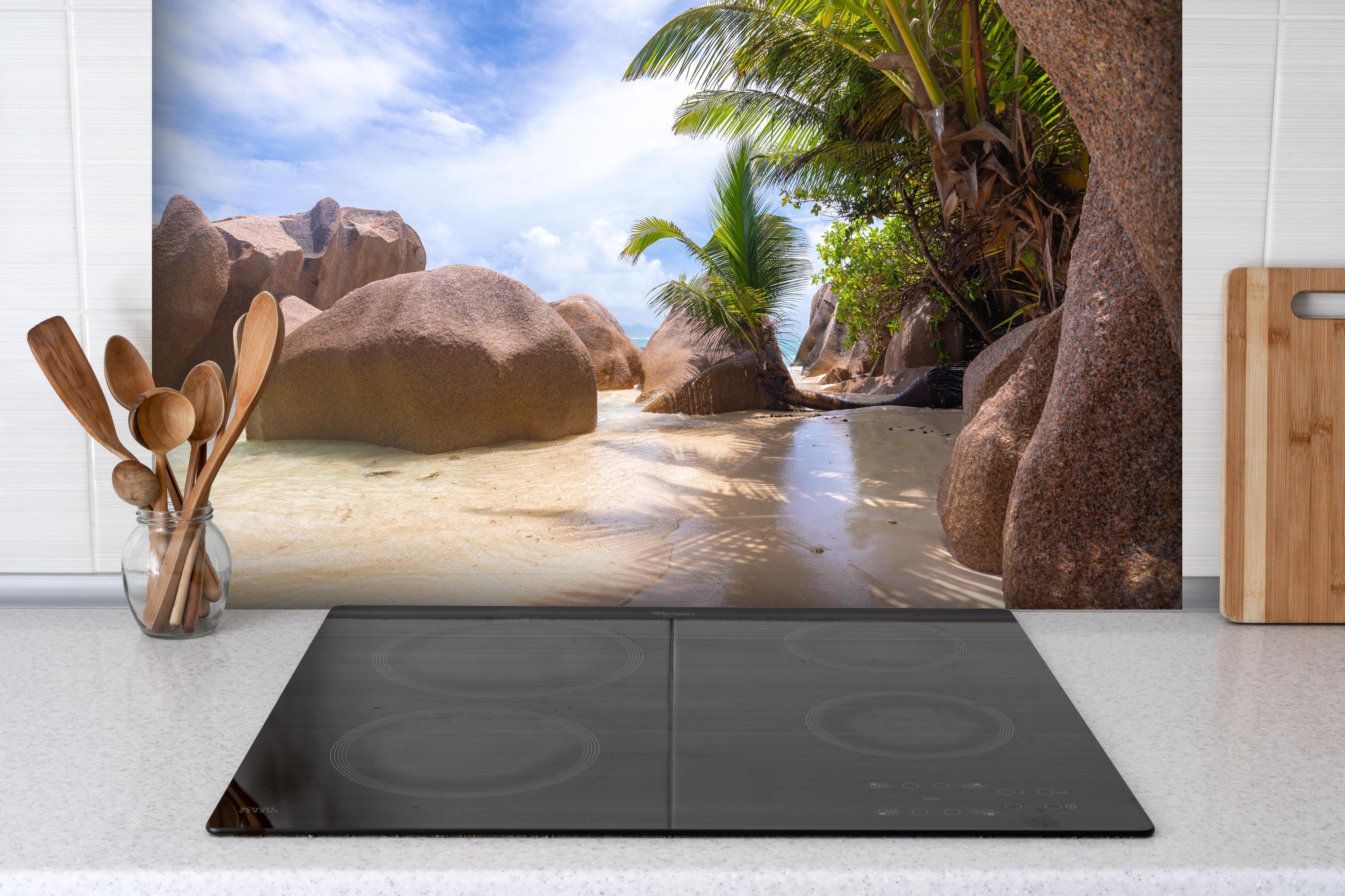 Spritzschutz - Der Traumstrand - Anse Source d Argent hinter einem Cerankochfeld zwischen Holz-Kochutensilien