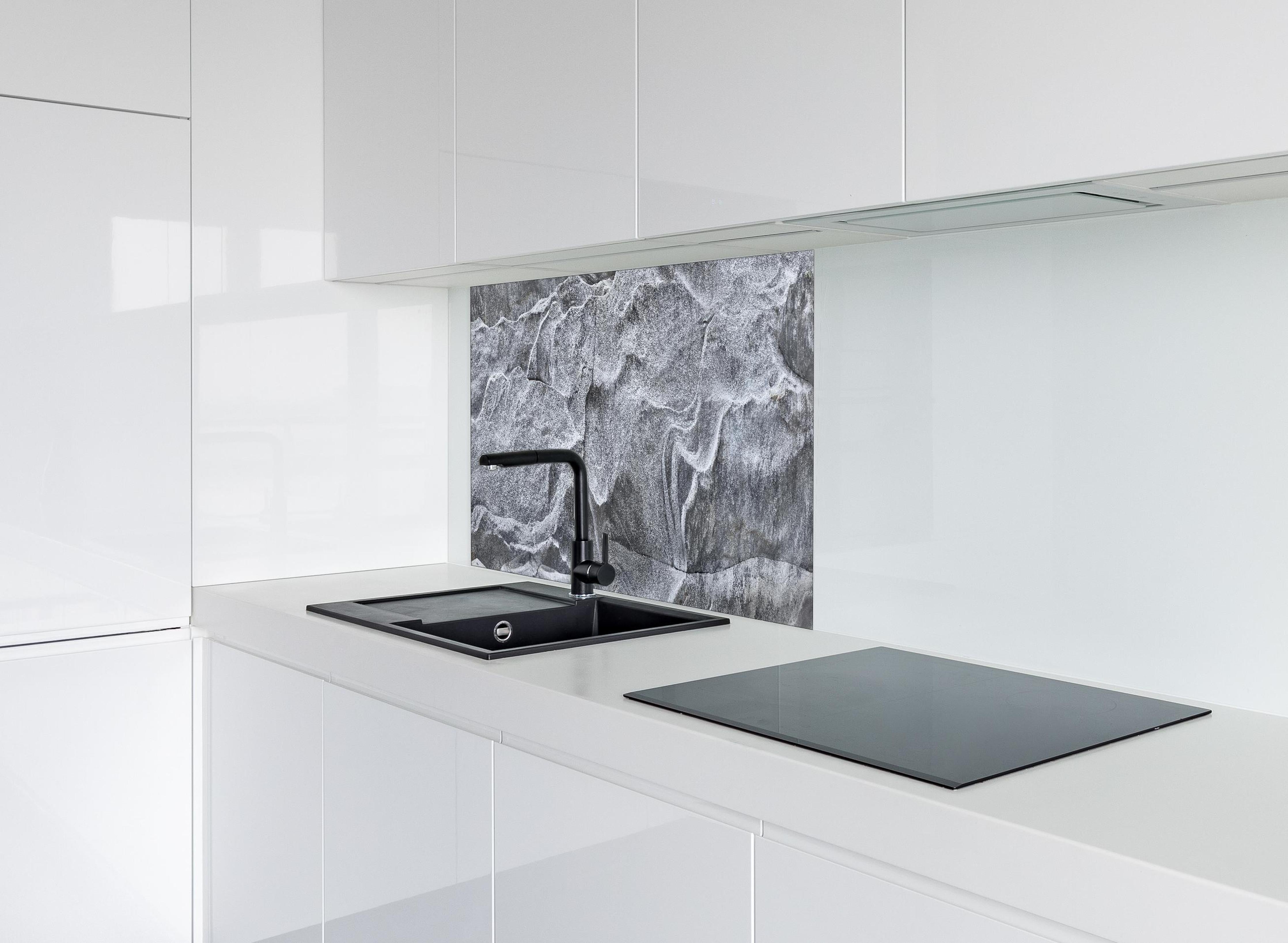 Spritzschutz - Detailaufnahme Grauer Fels Verzasca Fluss hinter einem Cerankochfeld zwischen Holz-Kochutensilien