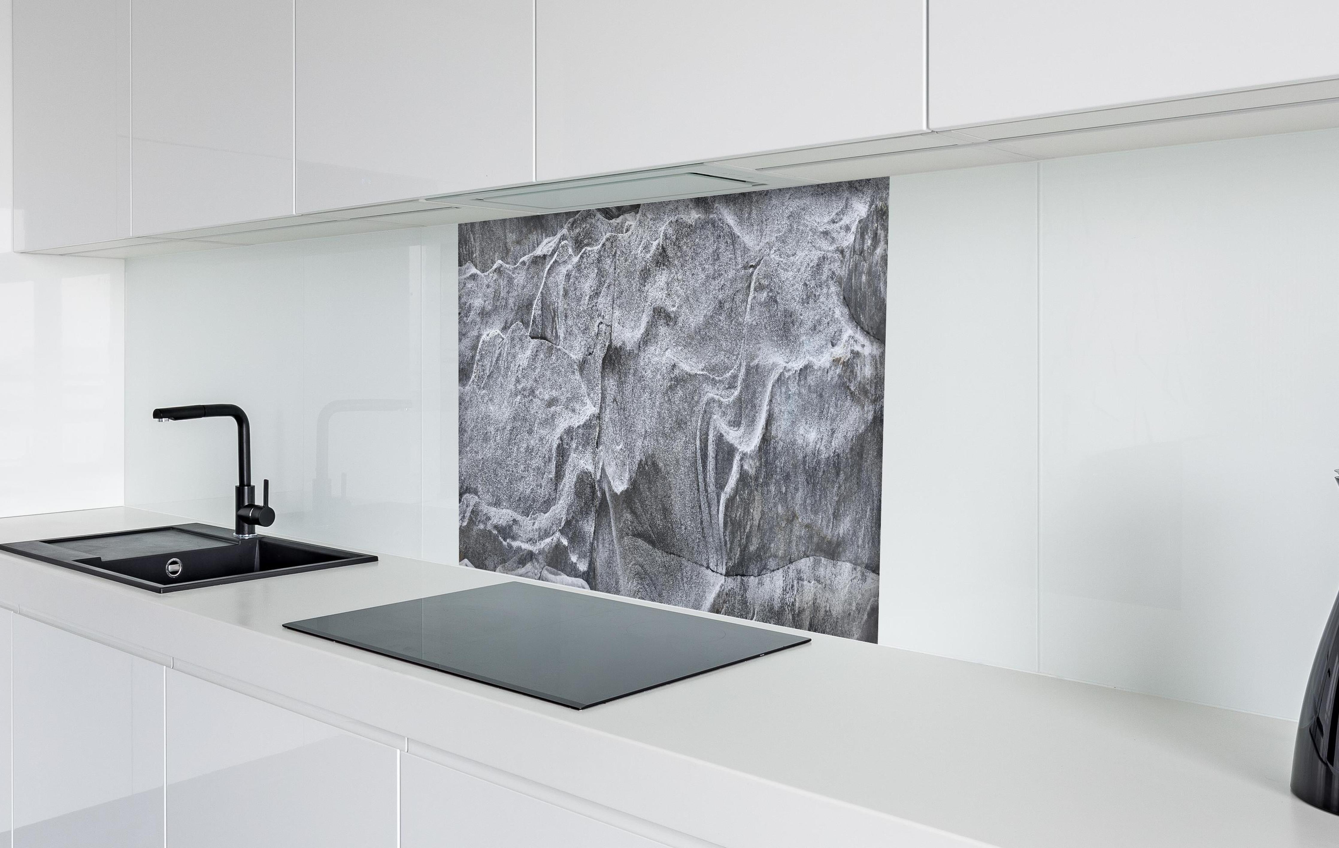 Spritzschutz - Detailaufnahme Grauer Fels Verzasca Fluss hinter einem Cerankochfeld zwischen Holz-Kochutensilien