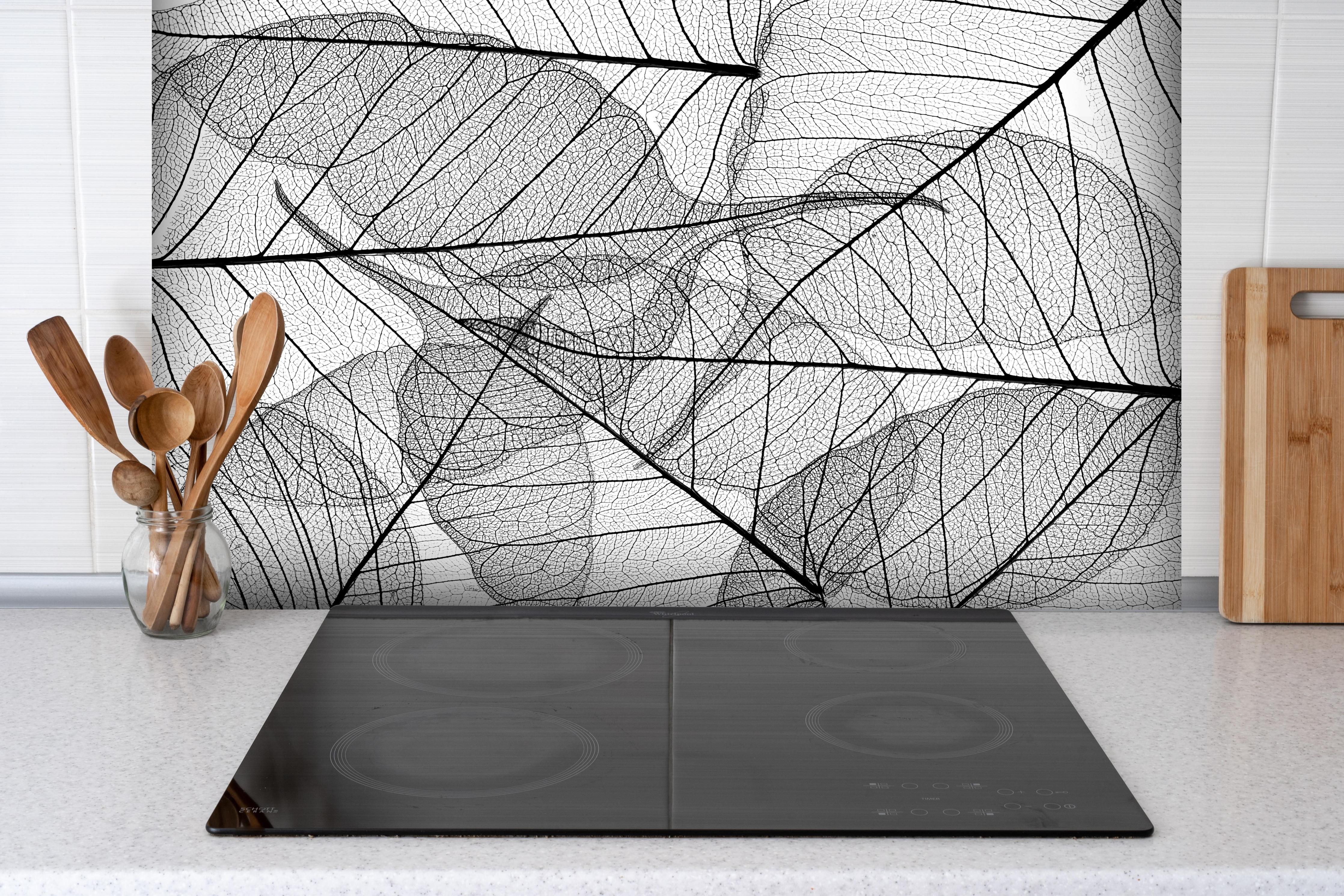 Spritzschutz - Detaillierte Schwarz-Weiße Laubtextur hinter einem Cerankochfeld zwischen Holz-Kochutensilien