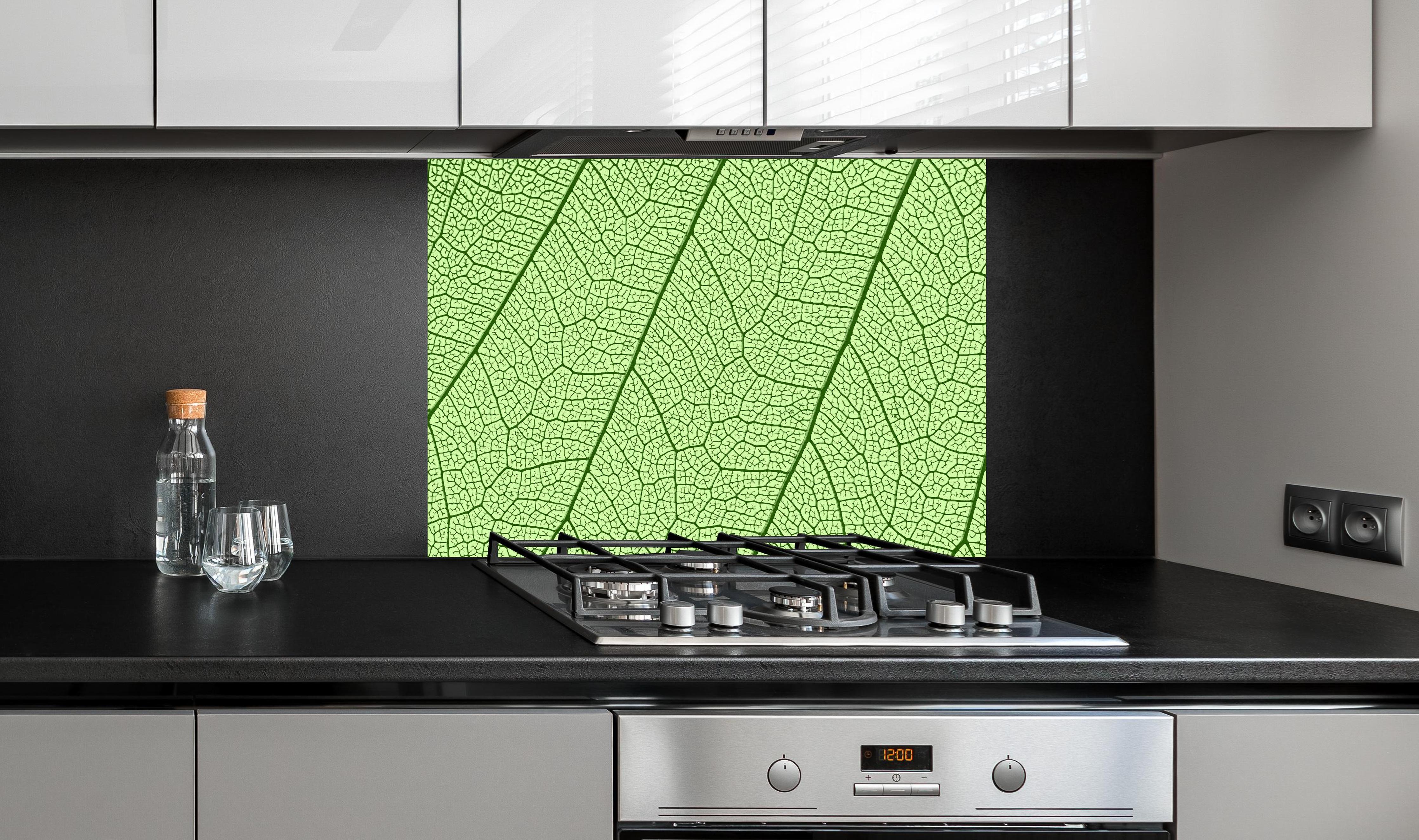 Spritzschutz - Detaillierte grüne Blattader Makro Textur hinter einem Cerankochfeld zwischen Holz-Kochutensilien