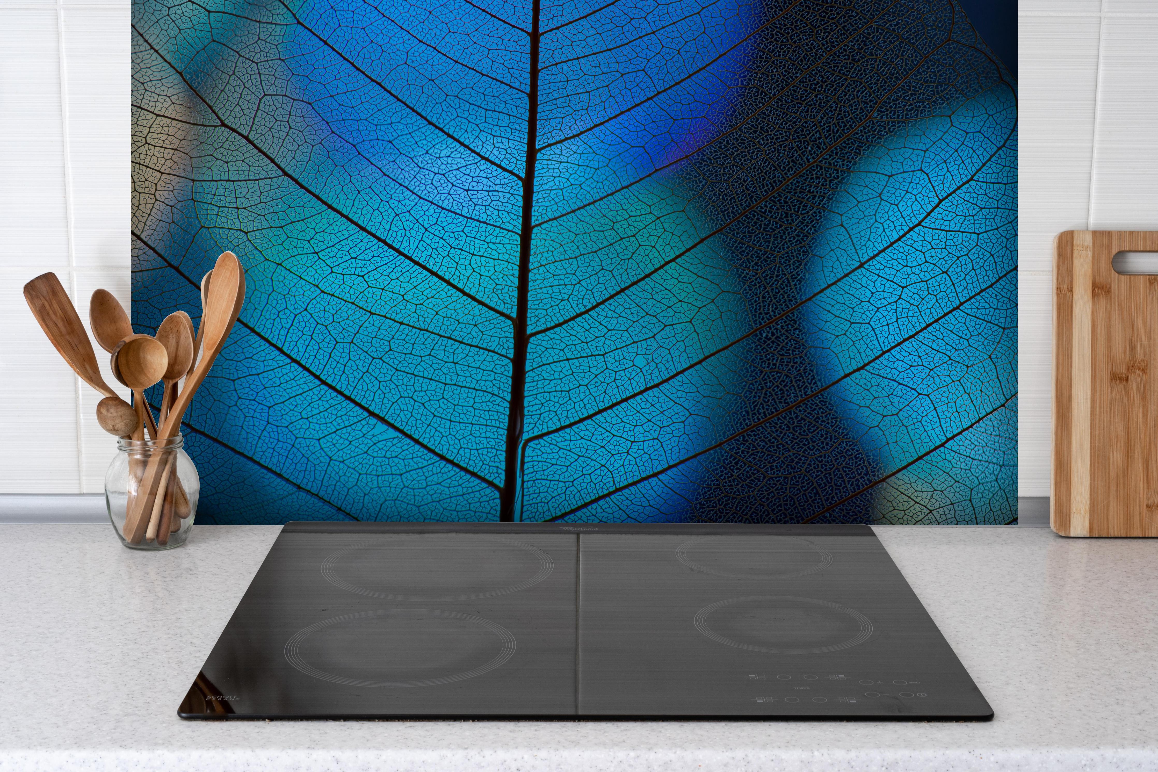 Spritzschutz - Detailreiche Blatt-Textur mit Adern hinter einem Cerankochfeld zwischen Holz-Kochutensilien