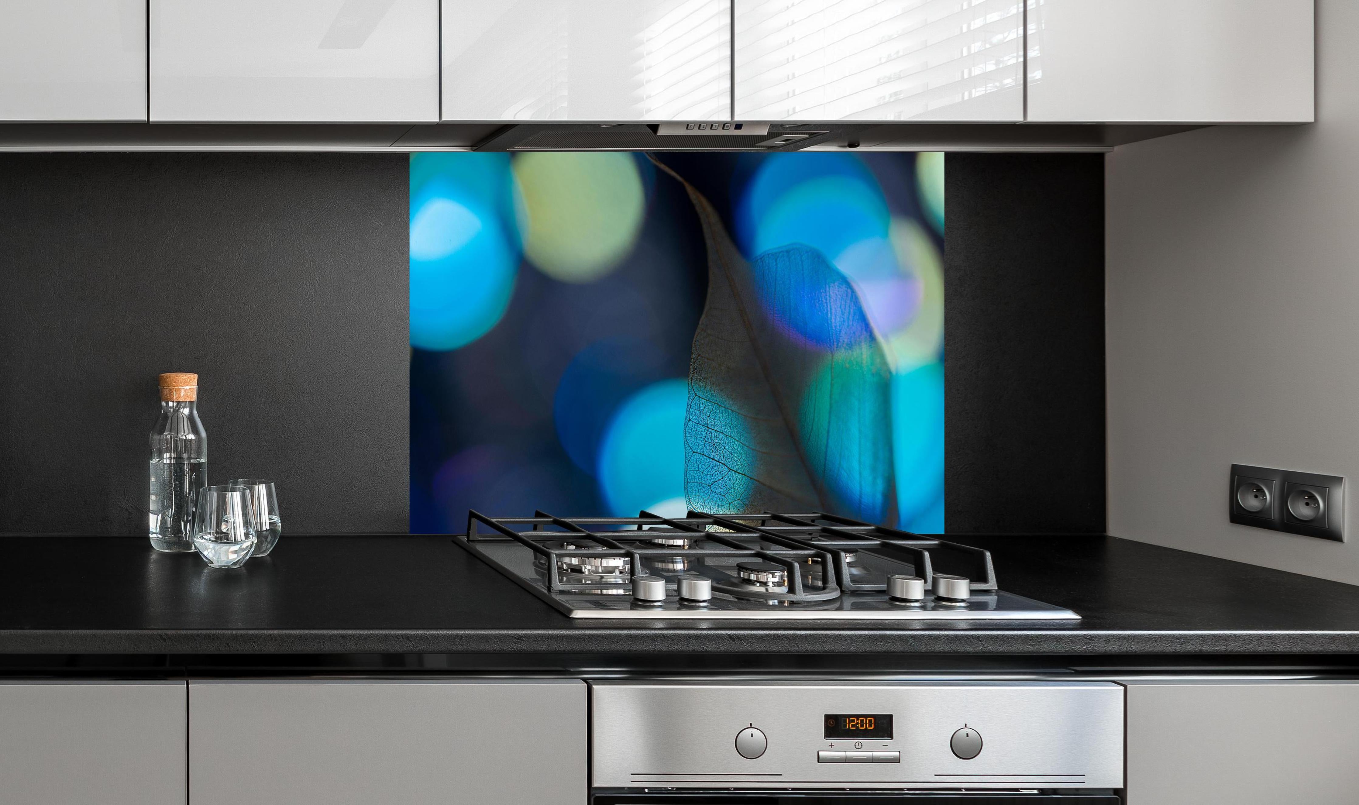 Spritzschutz - Detailreiche Blattader-Textur mit Farbspiel hinter einem Cerankochfeld zwischen Holz-Kochutensilien