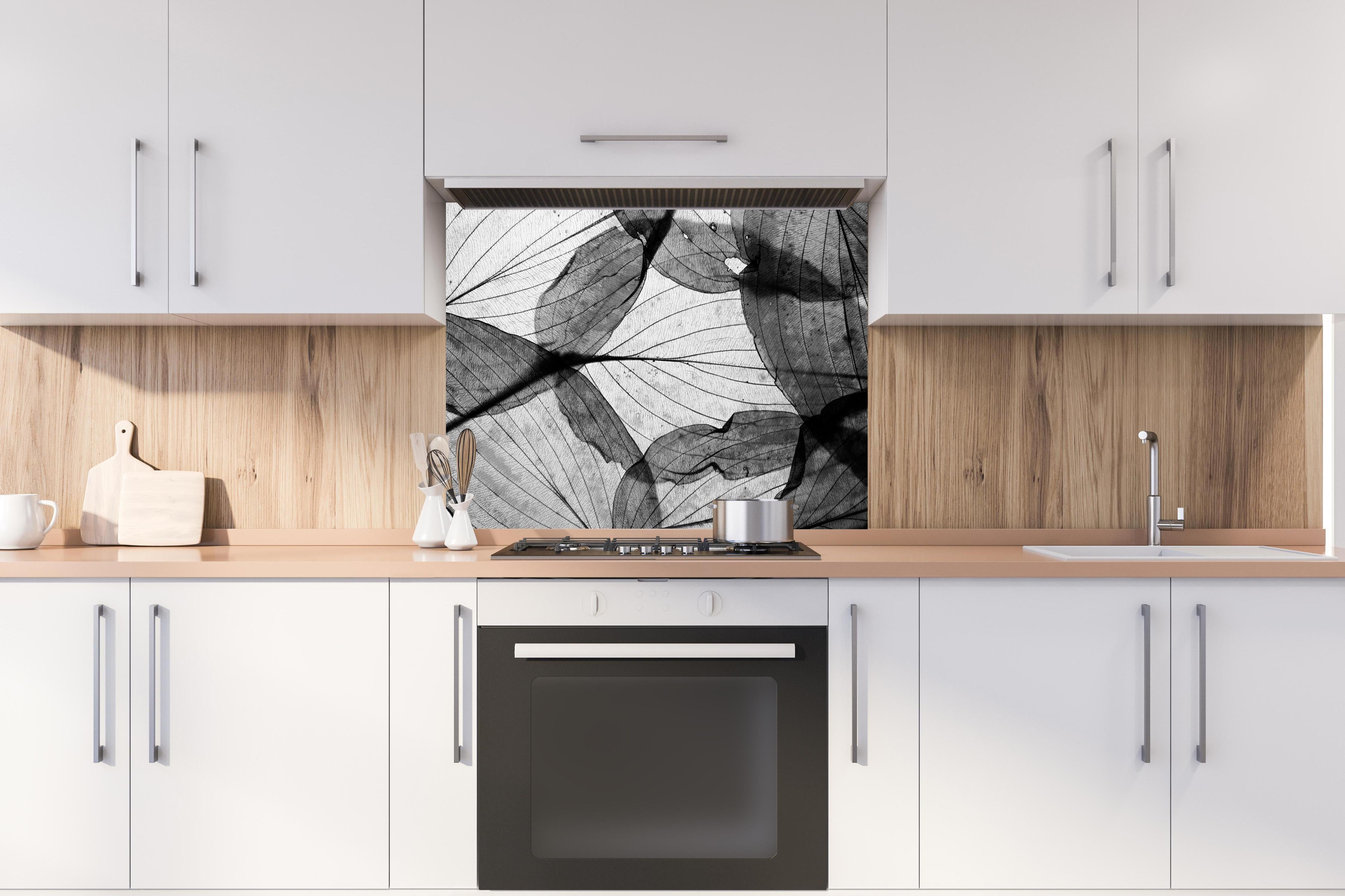 Spritzschutz - Detailreiche Schwarz-Weiße Laubtextur hinter einem Cerankochfeld zwischen Holz-Kochutensilien