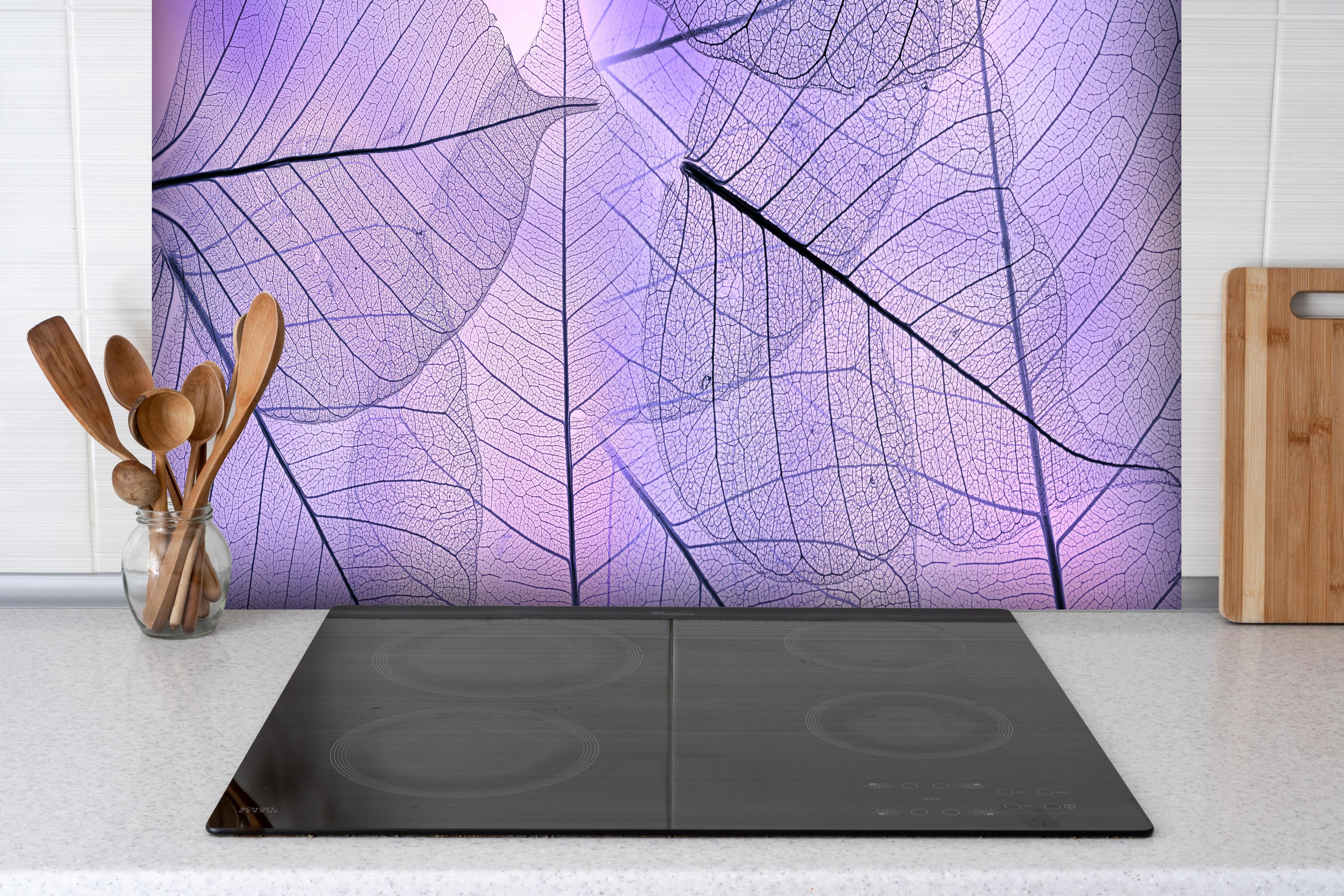 Spritzschutz - Detailreiche lila Blatt-Textur Nahaufnahme hinter einem Cerankochfeld zwischen Holz-Kochutensilien